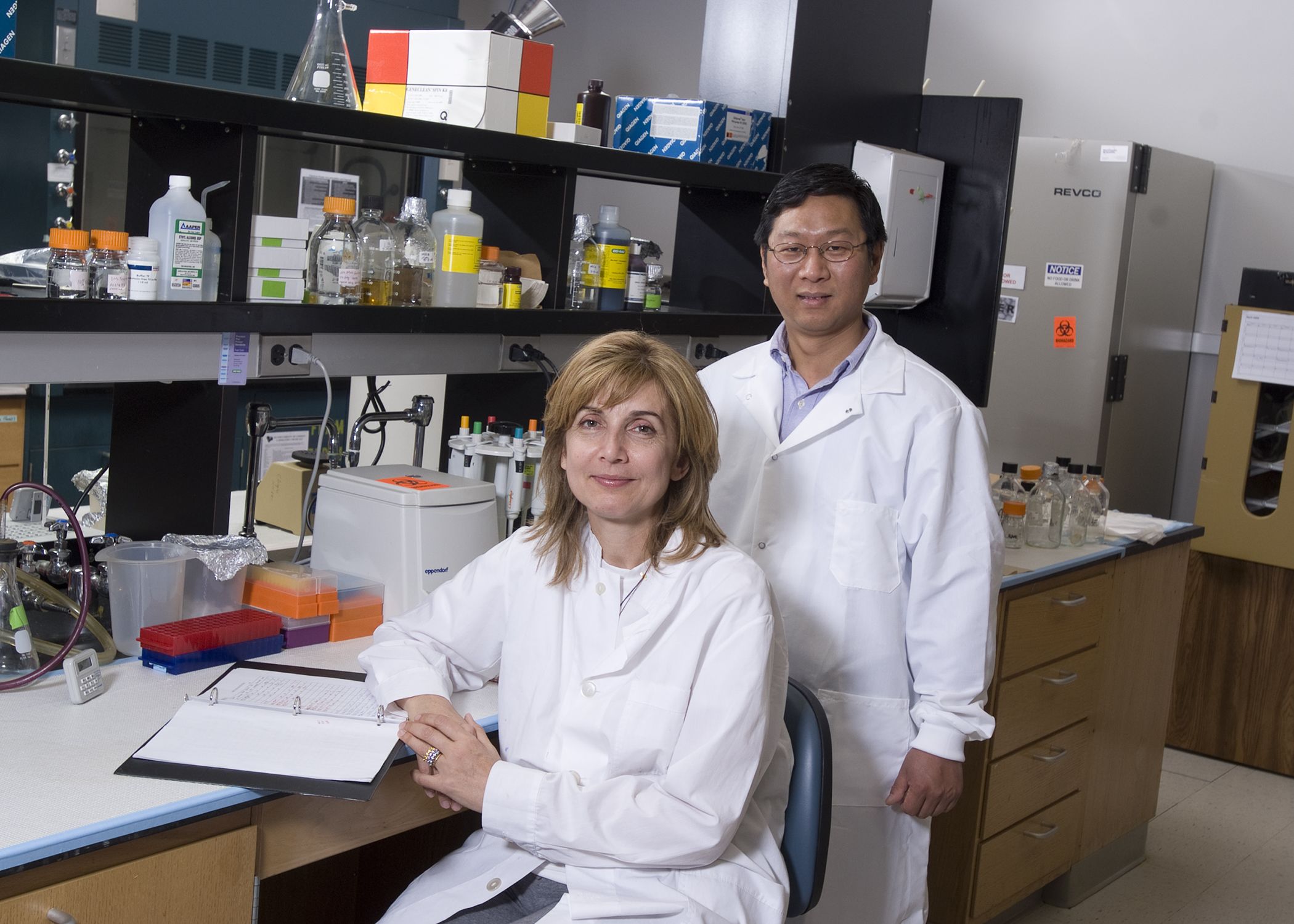 Researchers Ioanna Skountzou and Chinglai Yang in white coats in a research lab.