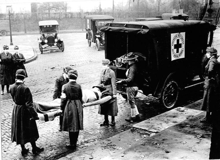 A patient on a stretcher being loaded into an ambulance during the 1918 pandemic.