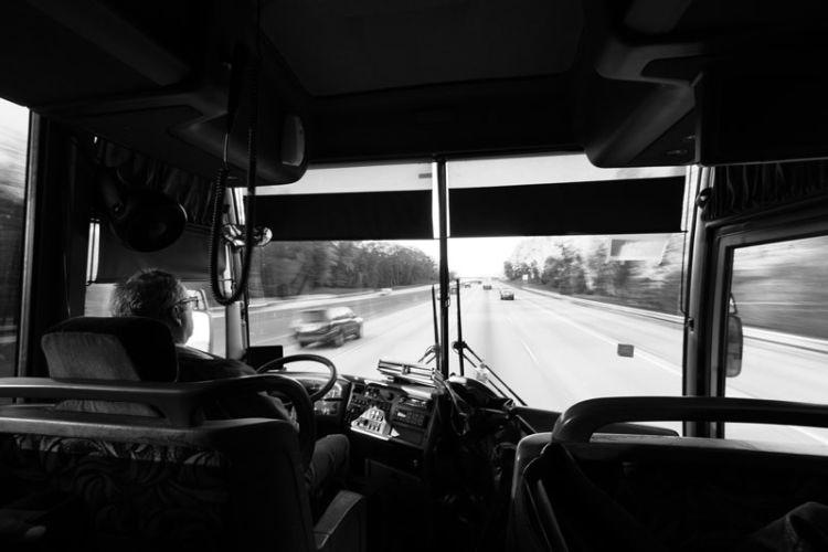 A photo shows the view from inside of a bus looking out through the windshield.