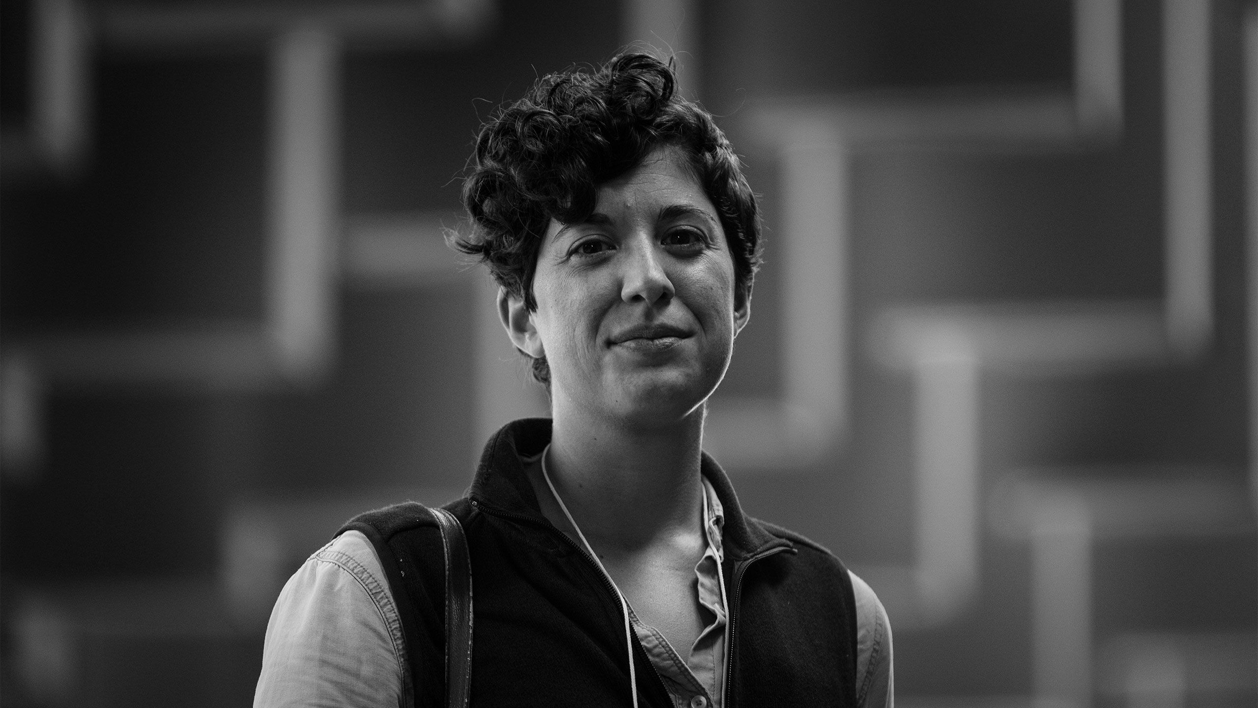 A portrait shows Jennifer Arnold wearing a vest and surrounded by shadows in the Memorial for Peace and Justice.