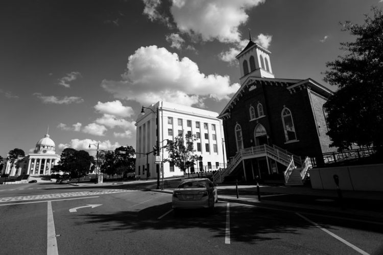 The Alabama capitol building is show on the left with the Dexter Avenue King Memorial Baptist Church just a few buildings down on the right side of the frame.