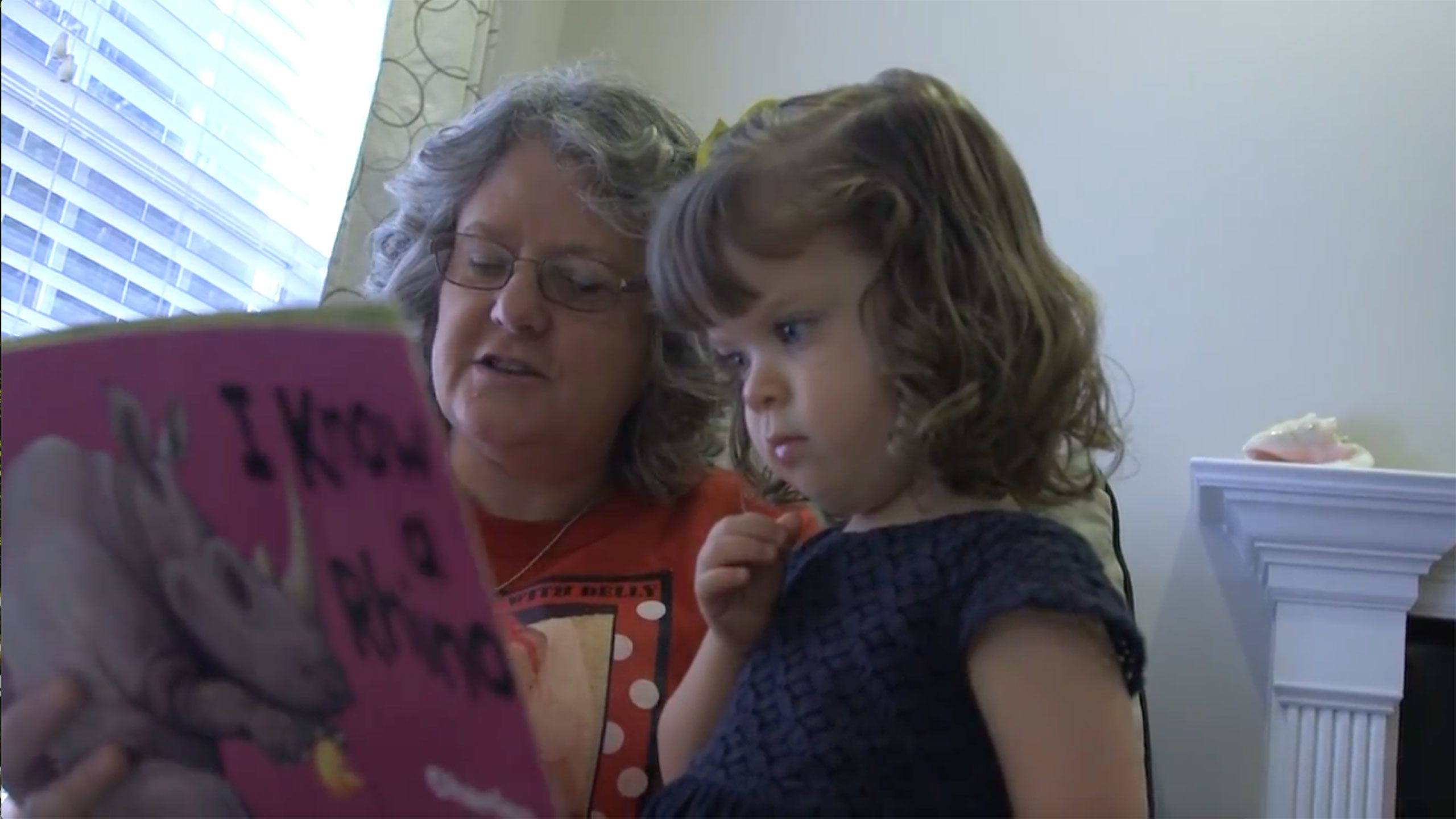 Jamie MicNell reads to her two-year old granddaughter