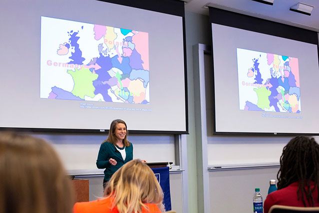 A Laney Graduate School student gives a presentation in front of a projector