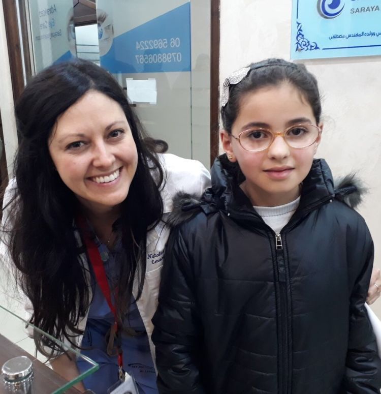 Image of Dr. Natalie Weil with a young girl wearing glasses
