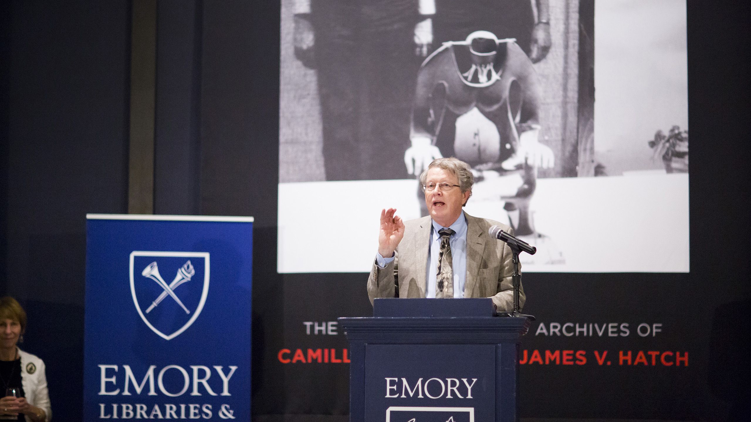 Burkett standing at a podium with Emory University branding