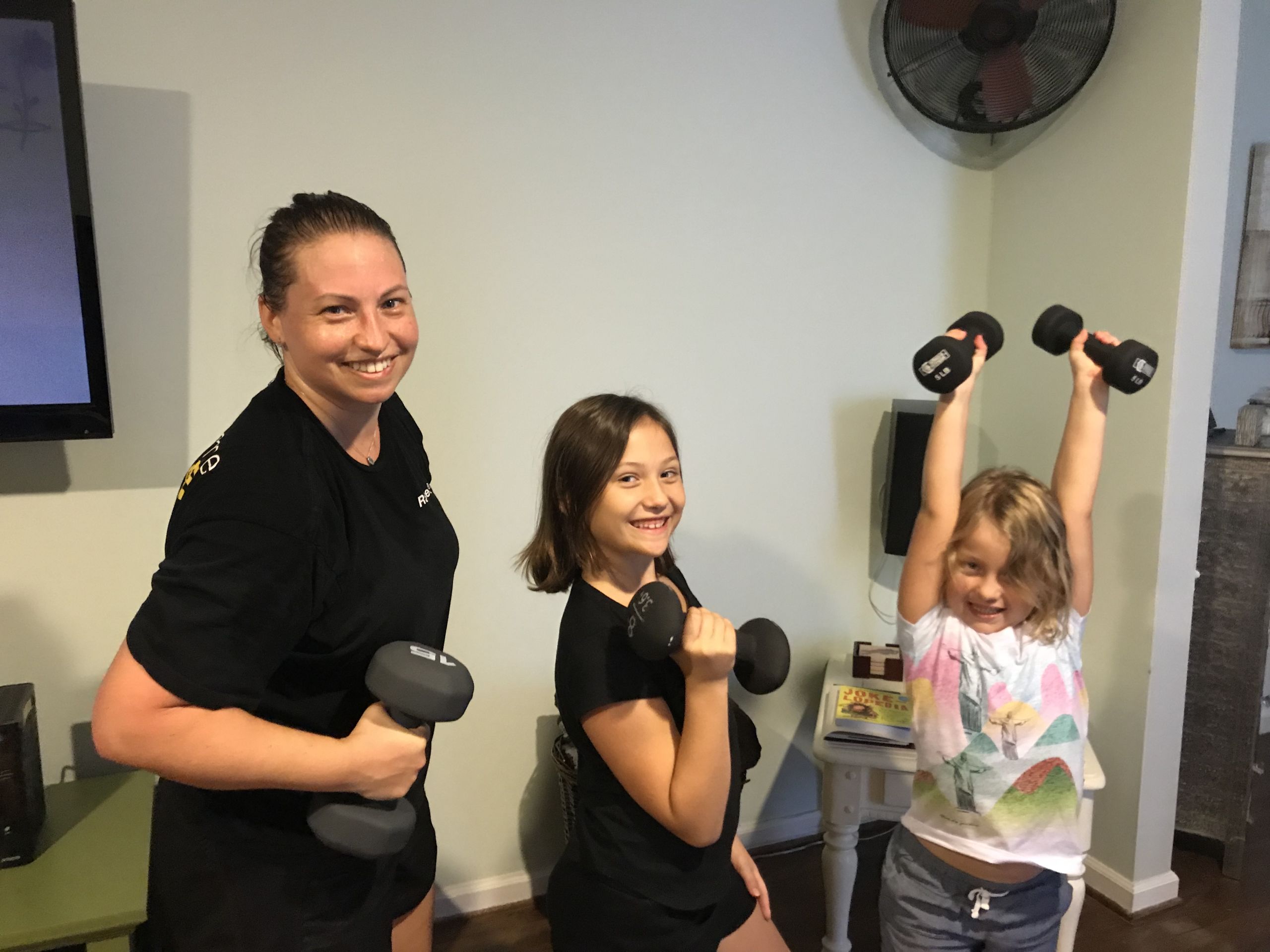Jessica Knight lifting hand weights with her two daughters.