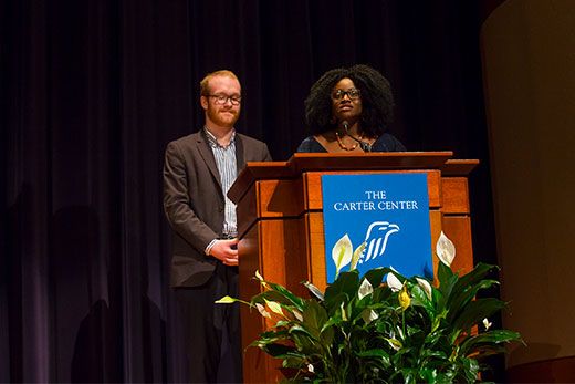 Oxford sophomores William Dewey and Josephine Mac-Arthur stand at a podium in The Carter Center.