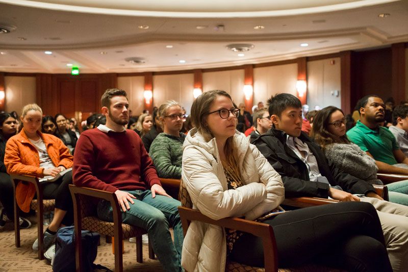 An auditorium is filled with people sitting in chairs listening to President Carter.