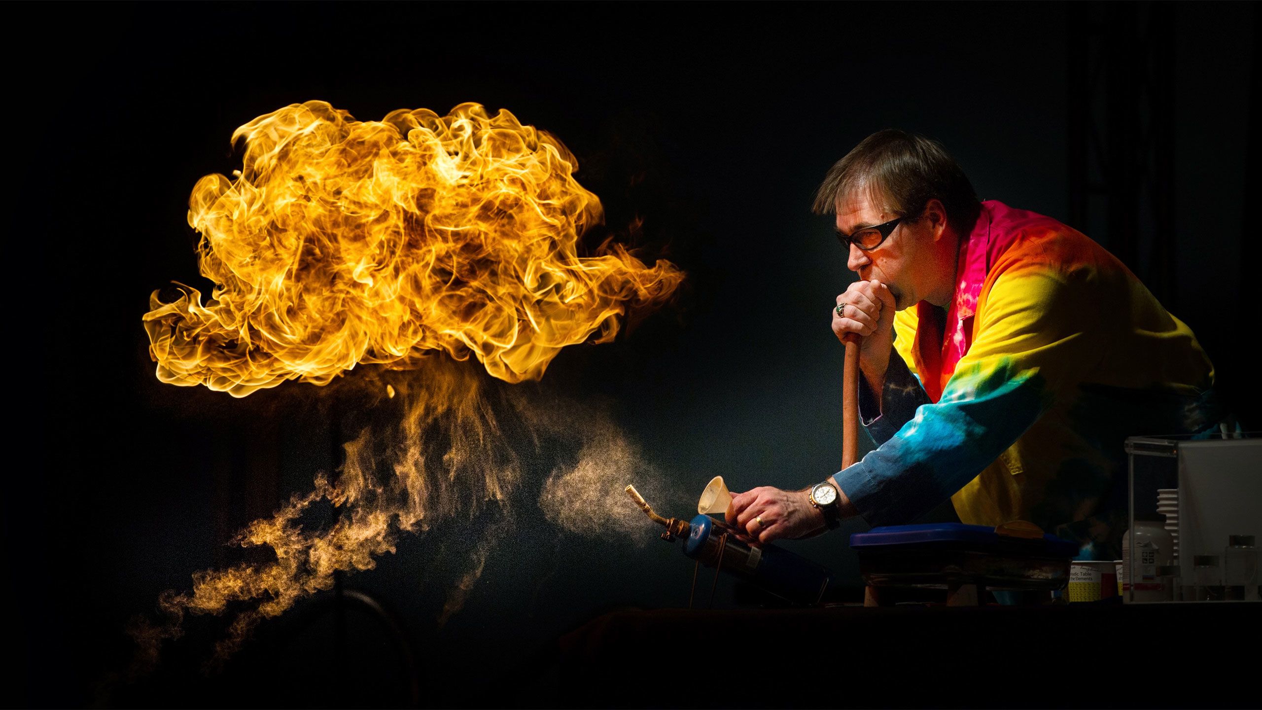 An Emory professor in a tie-dye labcoat conducts an experiment that results in a dramatic fireball.