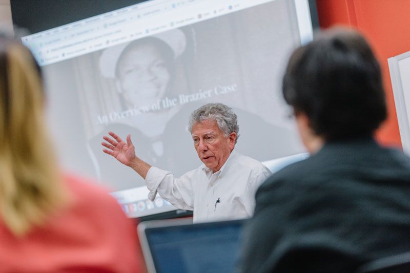 Hank Klibanoff speaks to a group of students in front of a projection screen