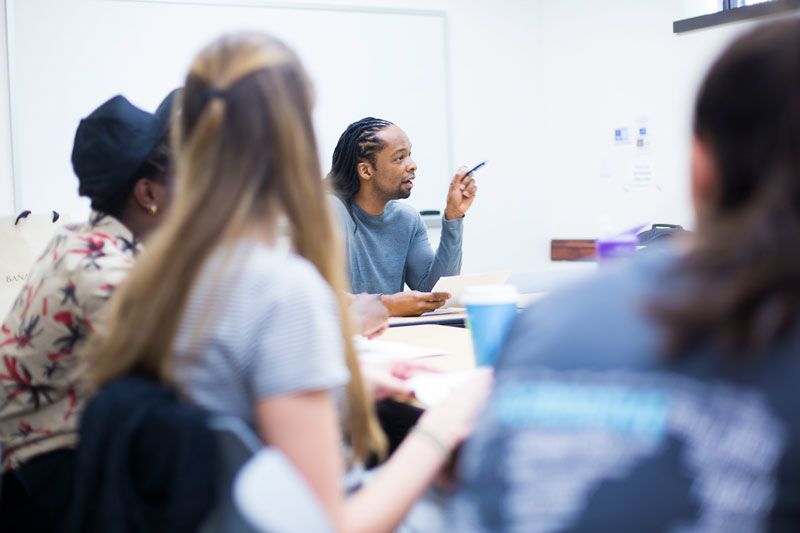 Jericho Brown sits at a seminar table surrounded by students