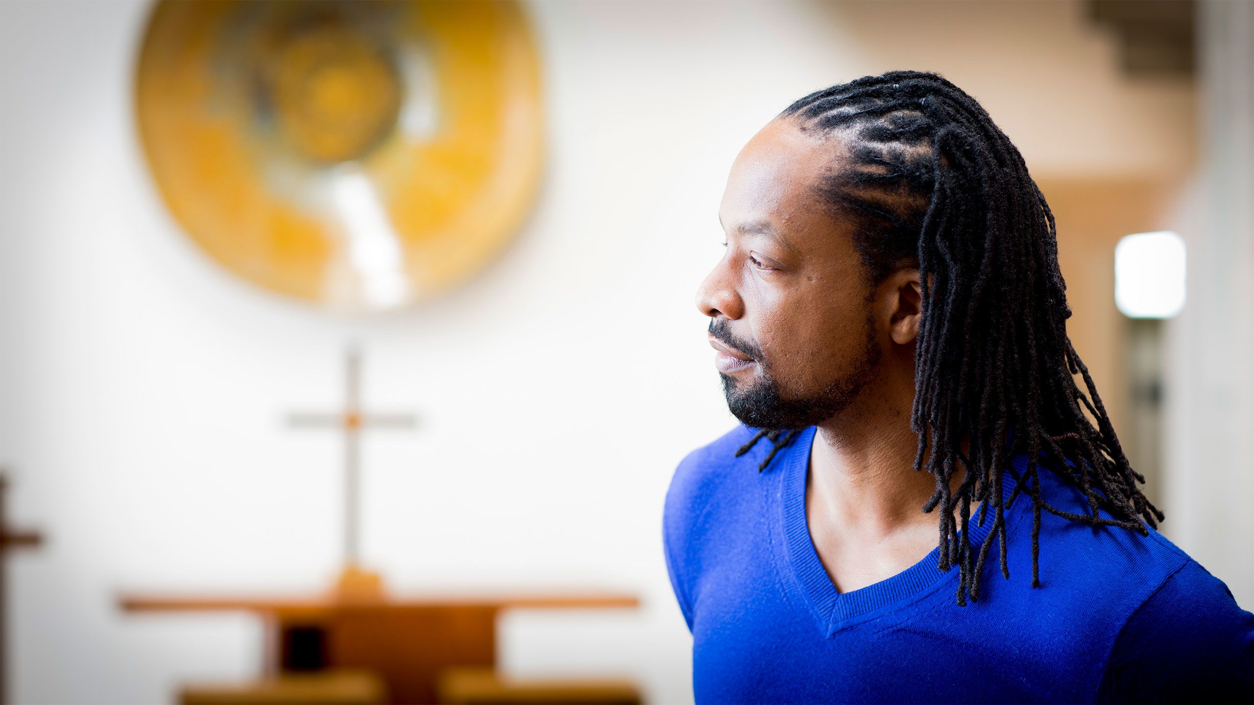 Poet and professor Jericho Brown appears in profile wearing a blue sweater