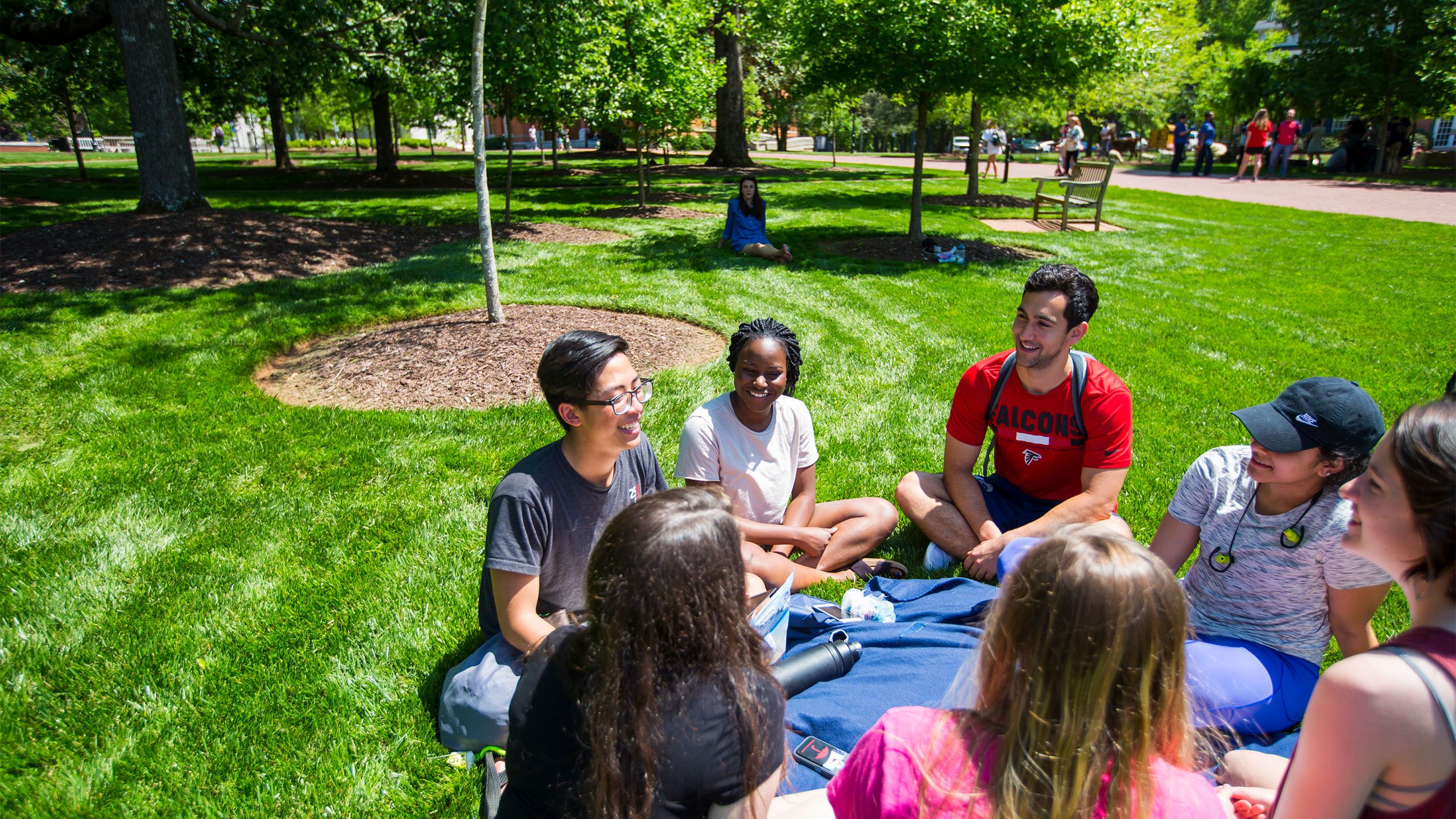 Oxford students sit in a circle talking on the quad