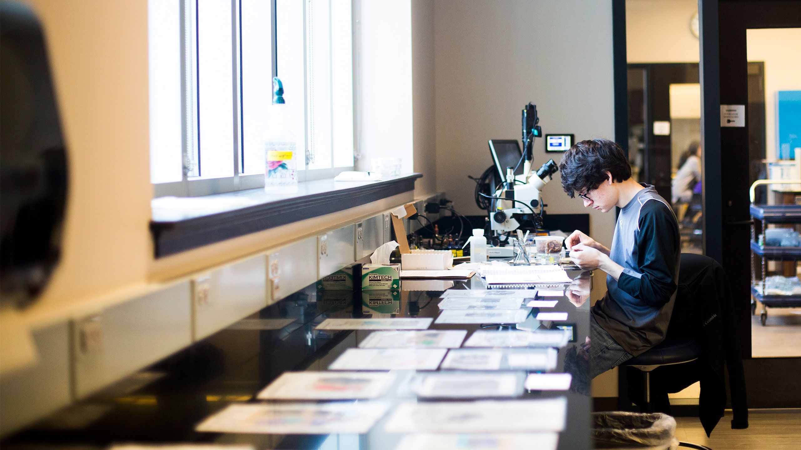 A student works with a microscope in the Oxford Science Building