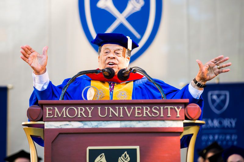 Wearing academic regalia, Andrew Young stands at the podium below the Emory seal