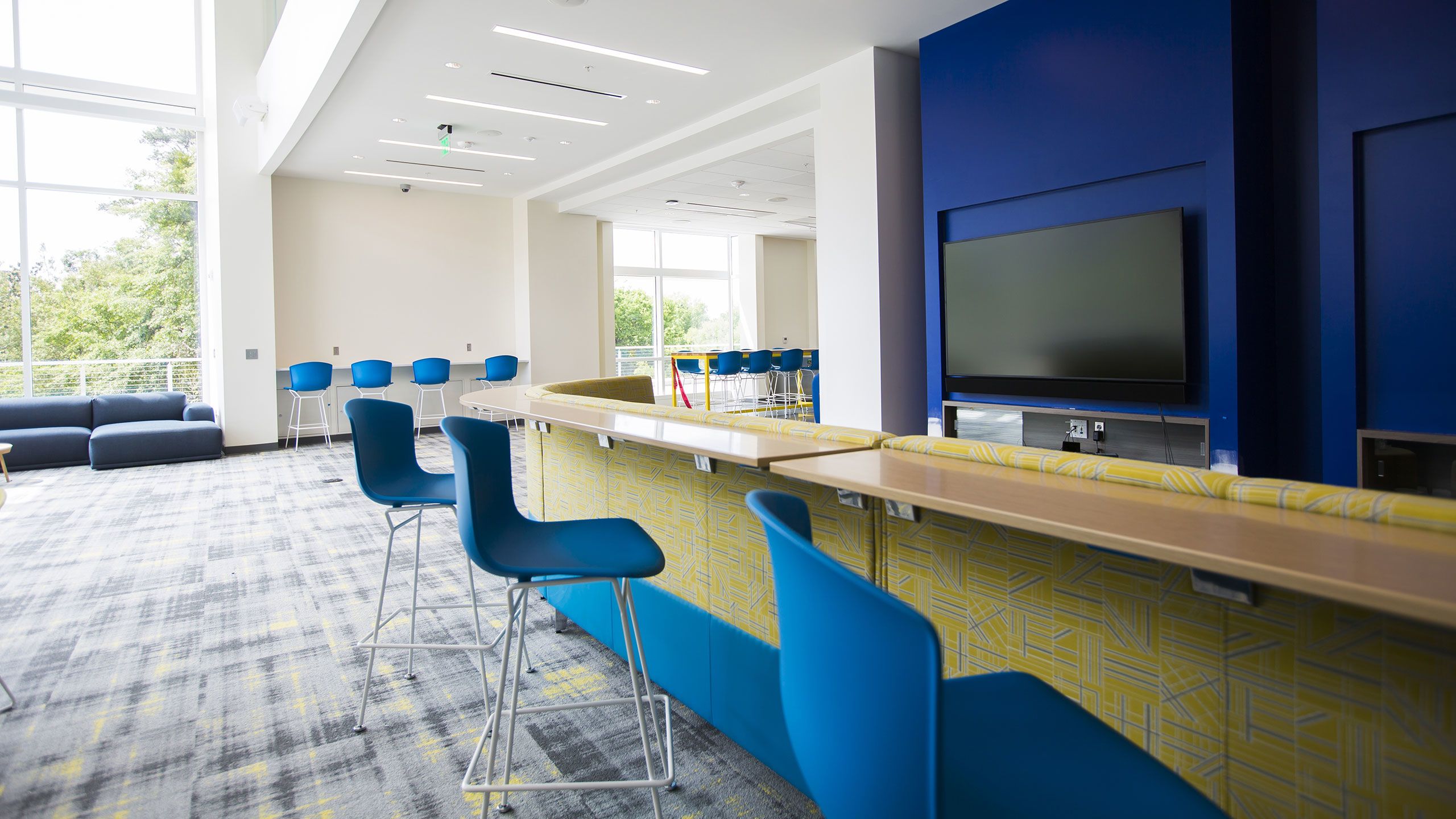 Bar-level seating faces 75-inch wall-mounted monitors