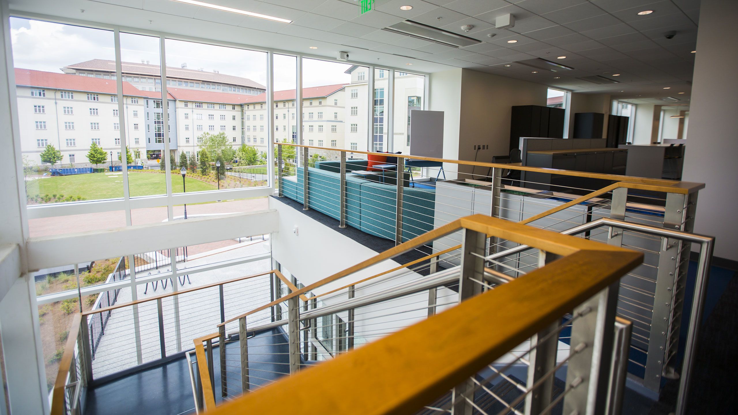 At the top of a staircase, the Student Involvement Lounge includes a long sectional and lots of storage with a view of the first-year residence halls