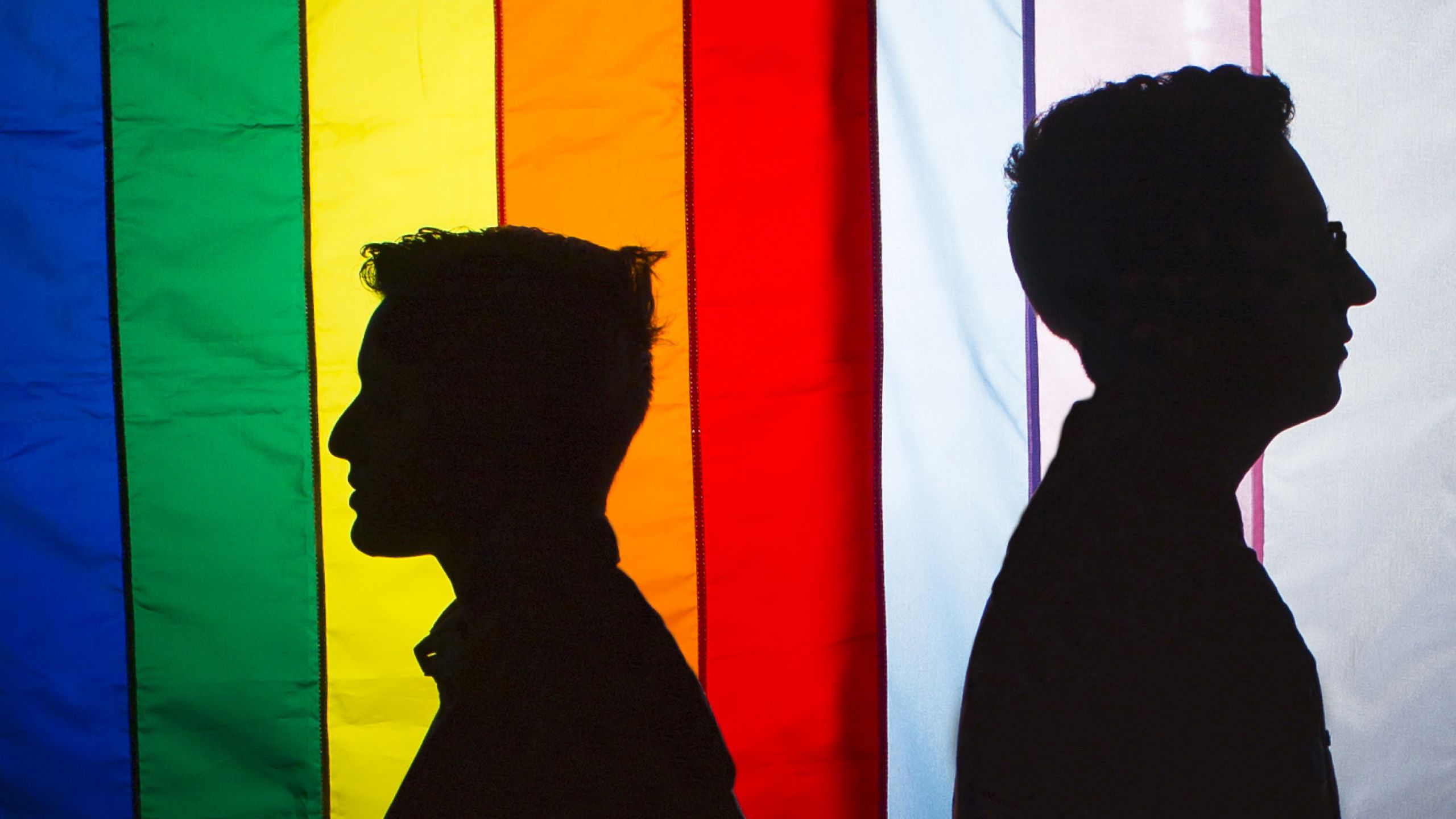 silhouette images with pride flag in background