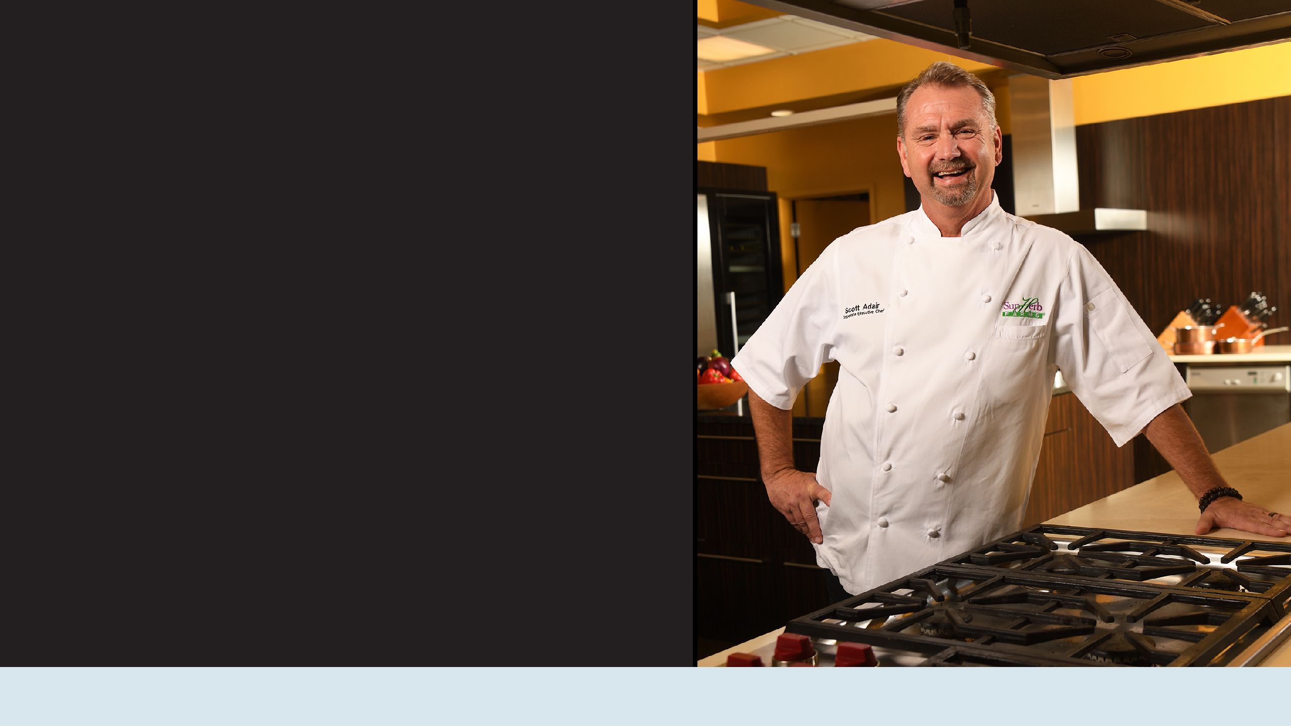 Chef Scott Adair in his chef's jacket in front of a cook range.