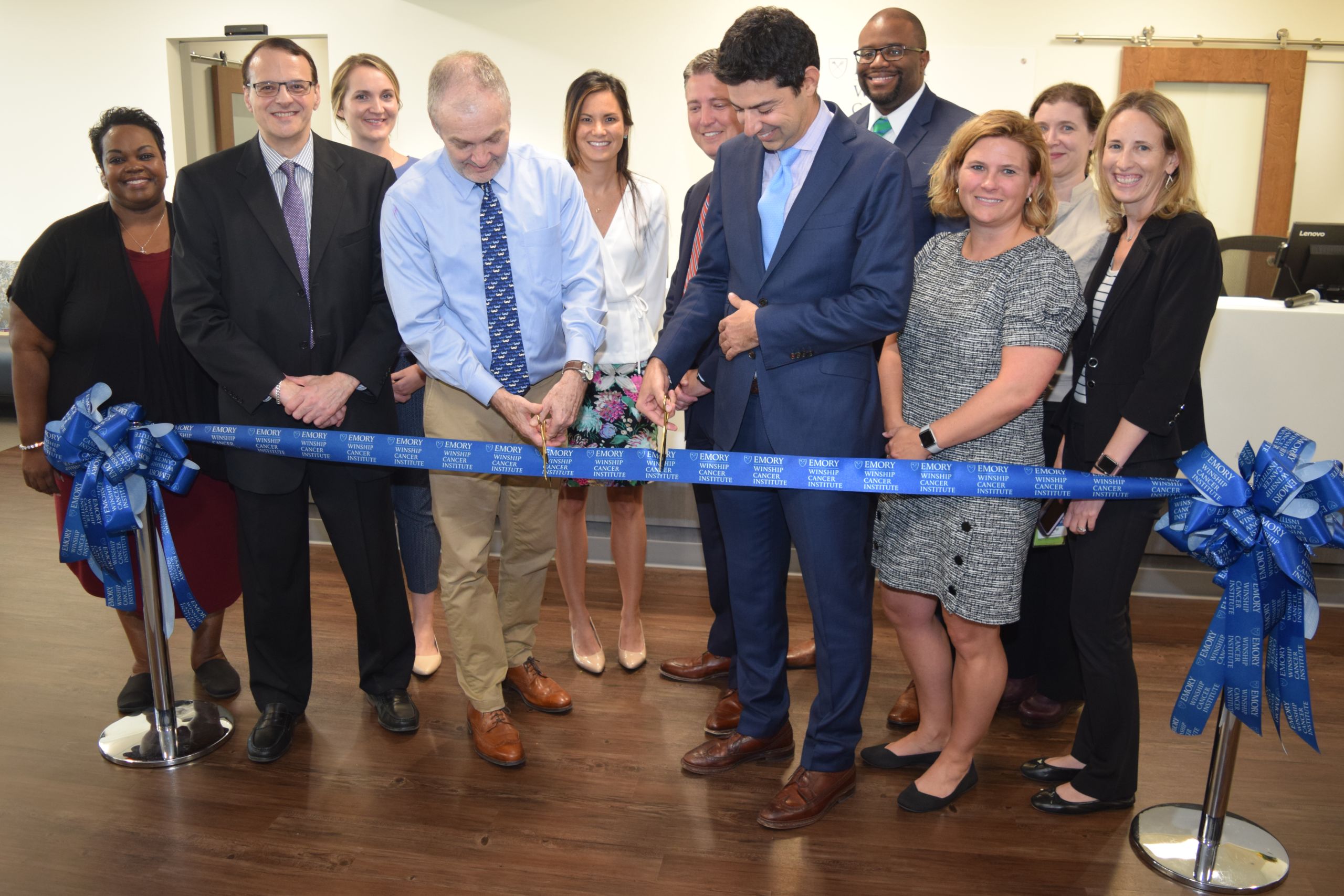 People line up to cut a blue ribbon in the head and neck oncology clinic