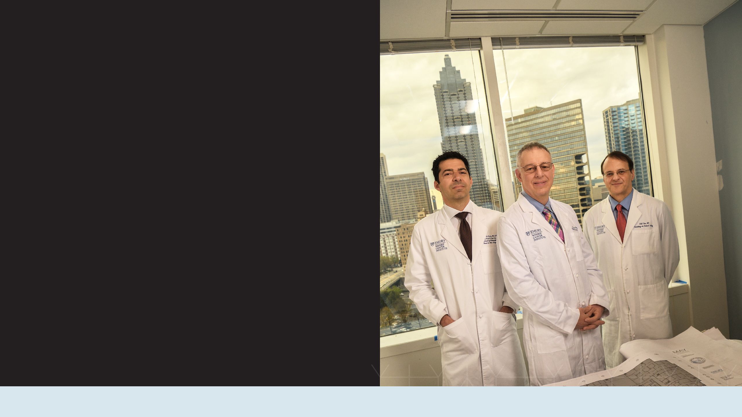 The three lead doctors for the head and neck cancer team in front of a window showing the Atlanta skyline. Pictured are Mark El-Deiry, Jonathan Beitler and Nabil Saba. 