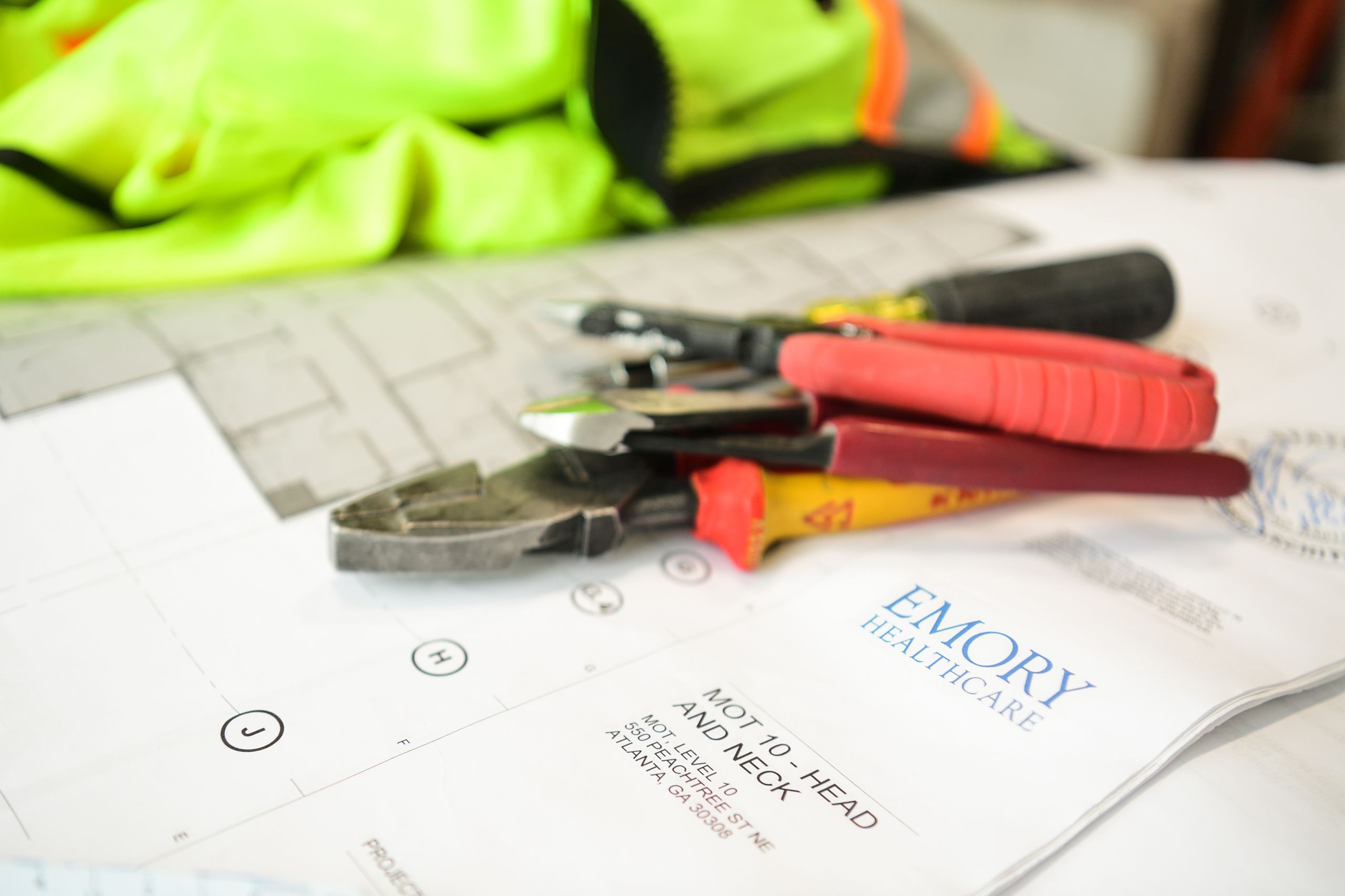 Construction tools are seen on top of an architectural plan for the new head and neck clinic. 