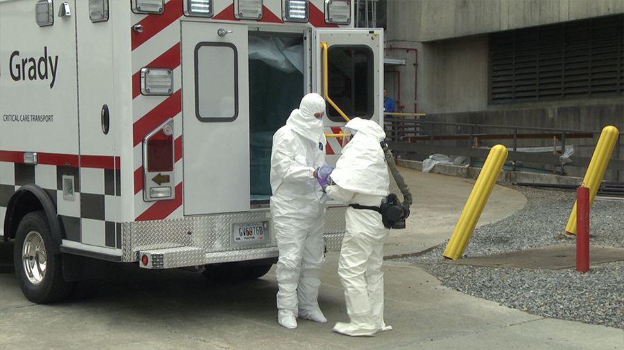 Kent Brantly assisted out of ambulance, all wearing PPE