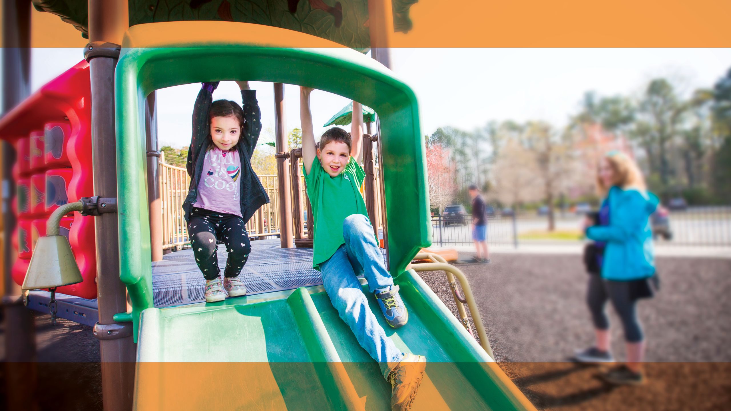 Elise and Amiel going down a slide together.