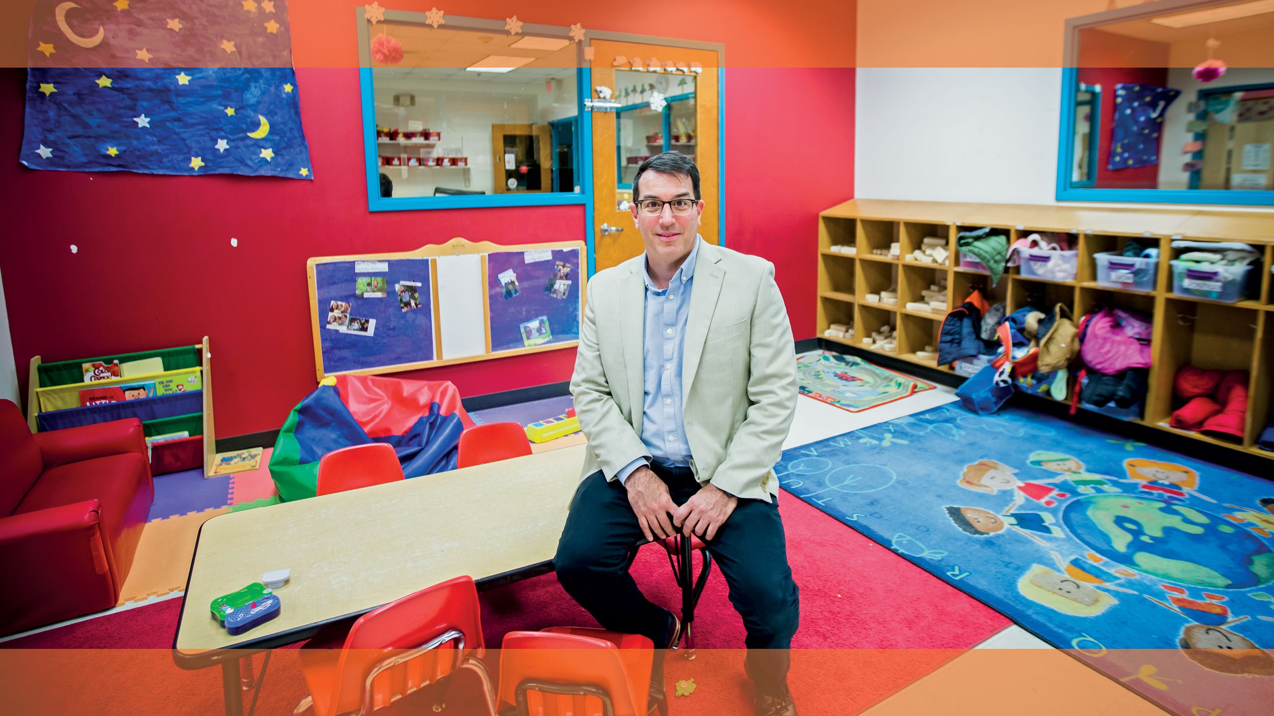 Michael Morrier sitting in a colorful pre-K classroom