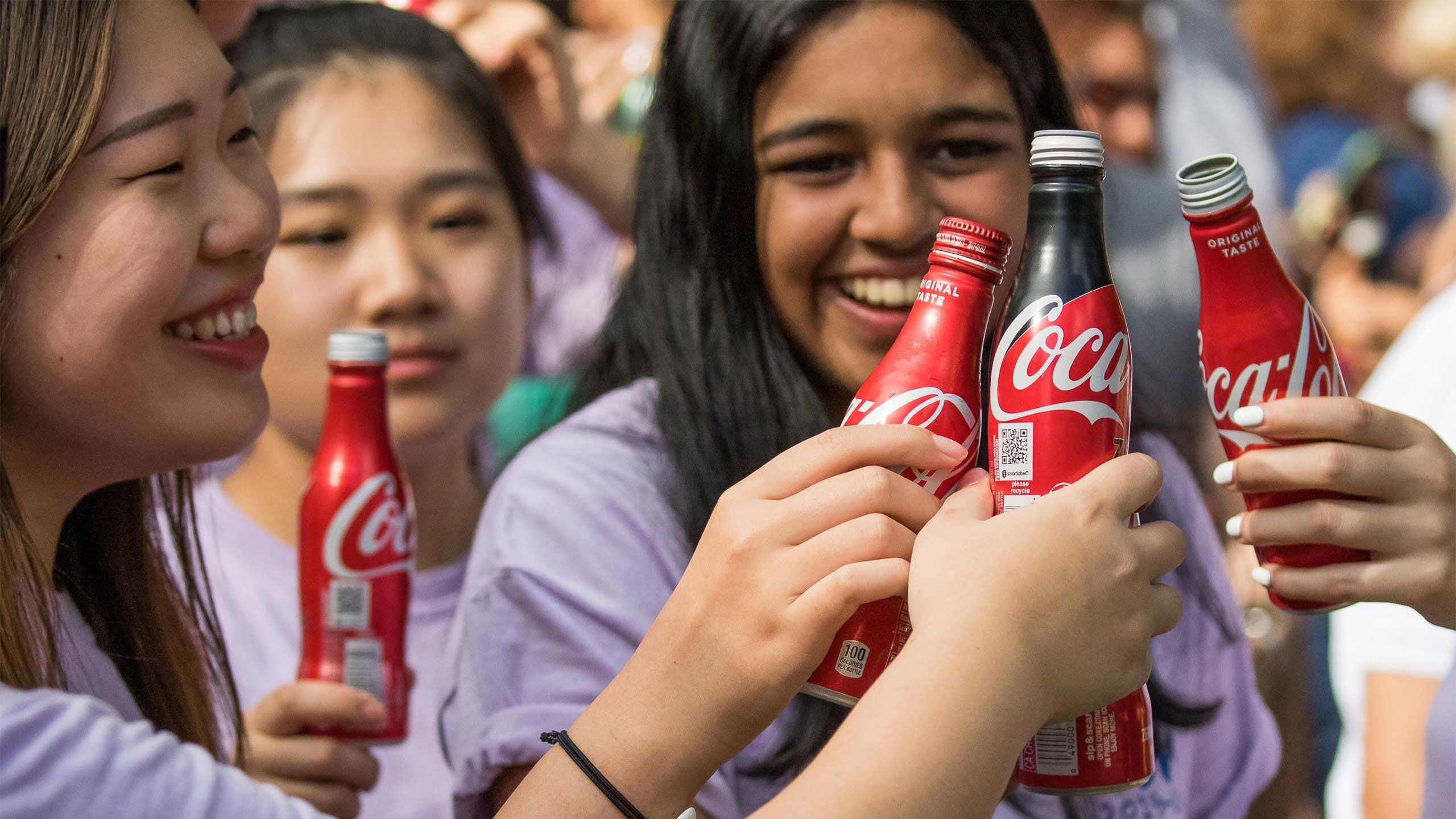 Students toast with Coca-Cola bottles