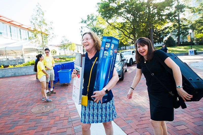 President Sterk carries boxes outside of a residence hall