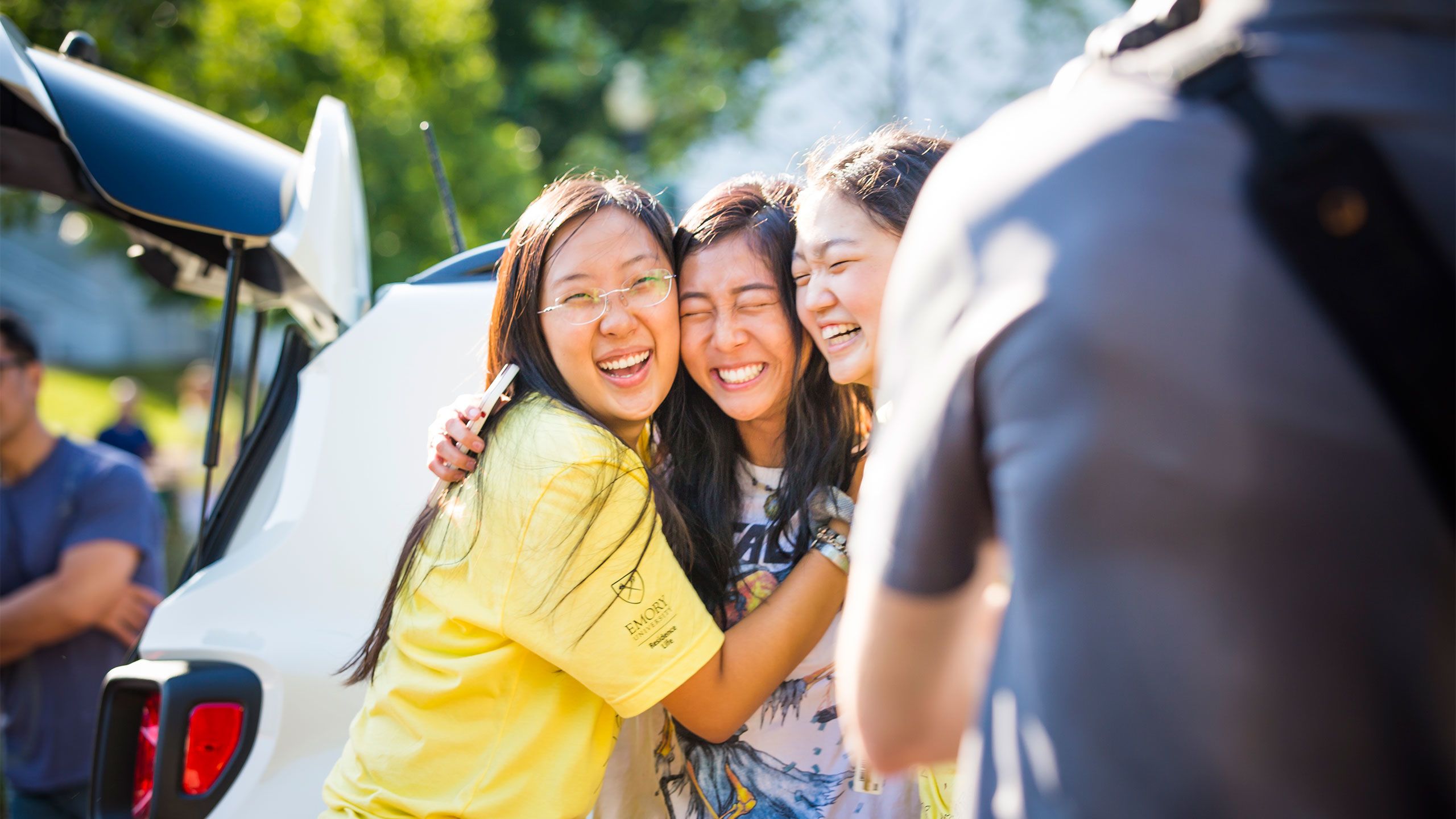 New students hug and smile as they pose for a photo