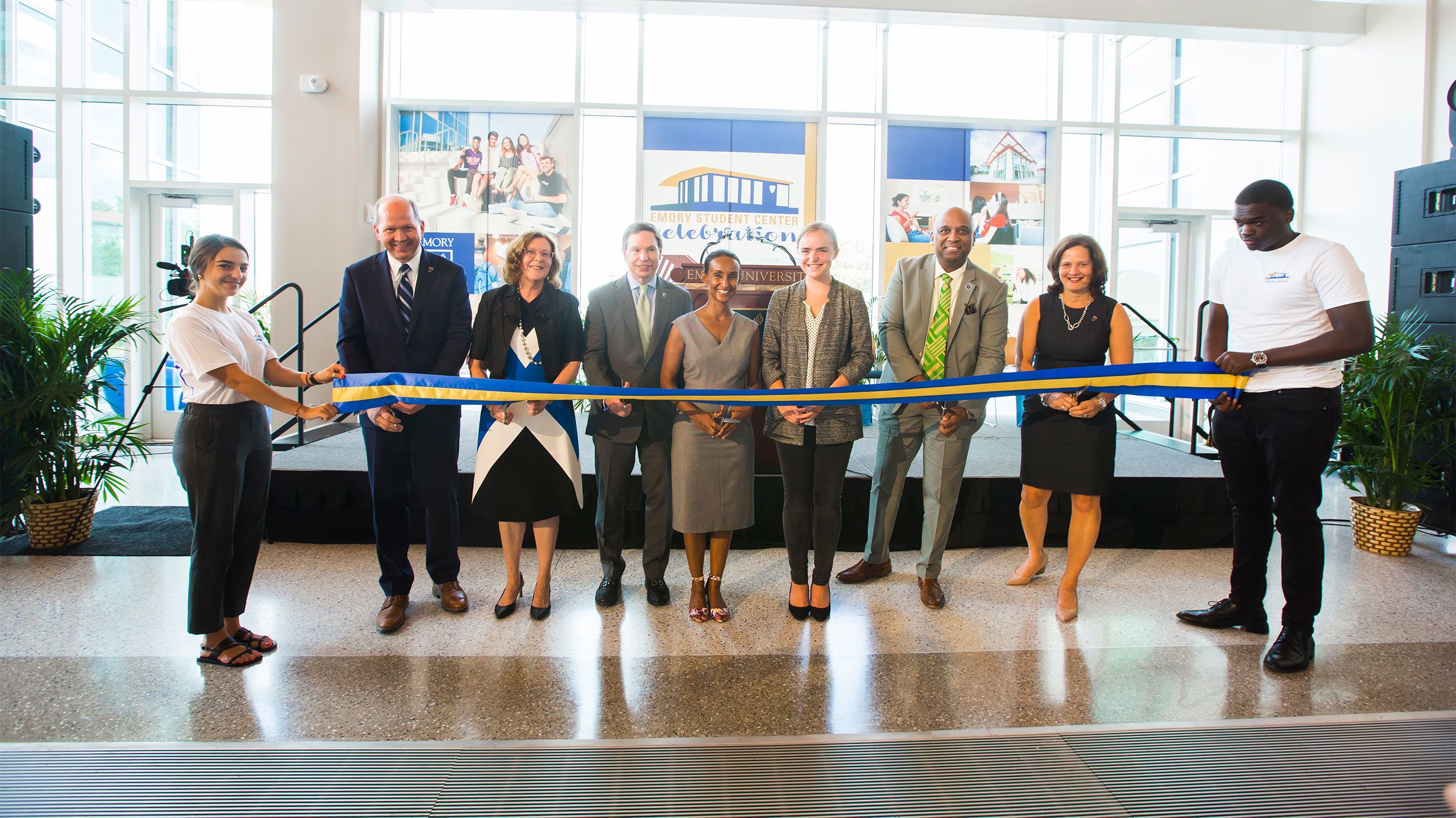 Emory leaders hold scissors poised to cut a blue and gold ribbon