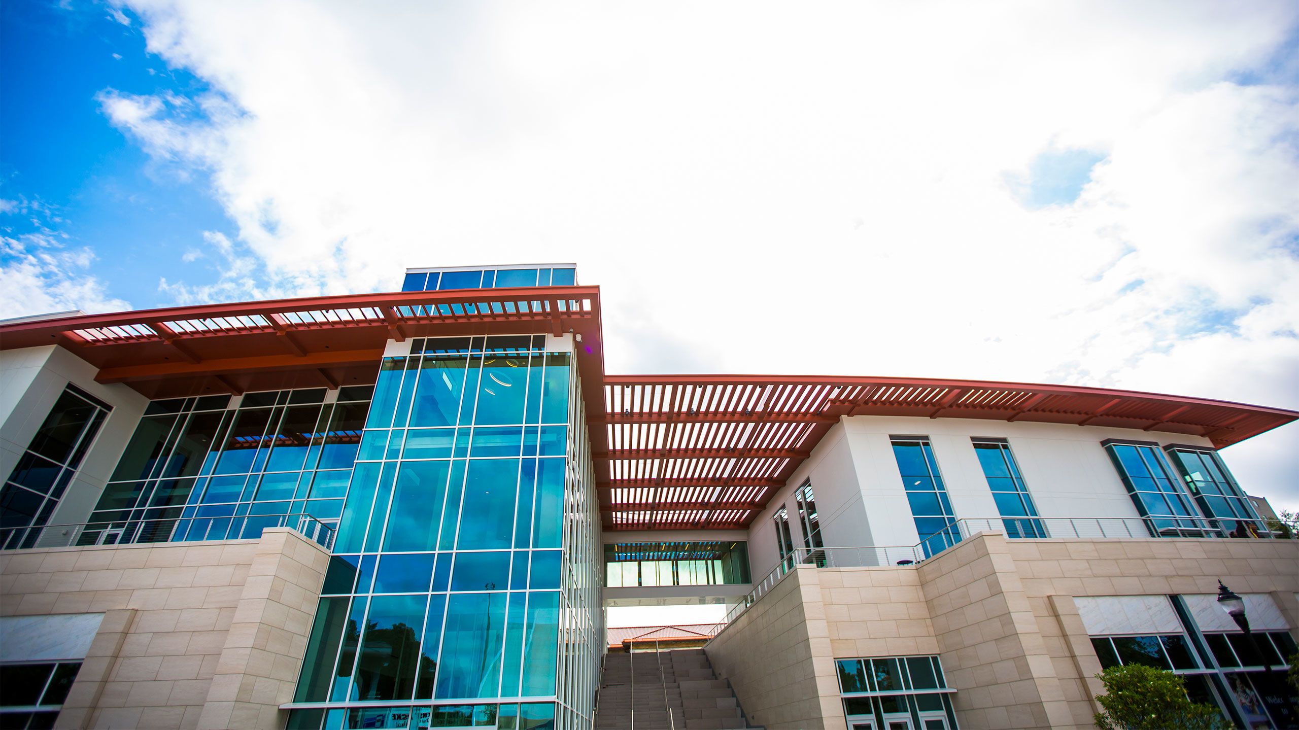 An exterior photo of the Emory Student Center with blue sky and white clouds
