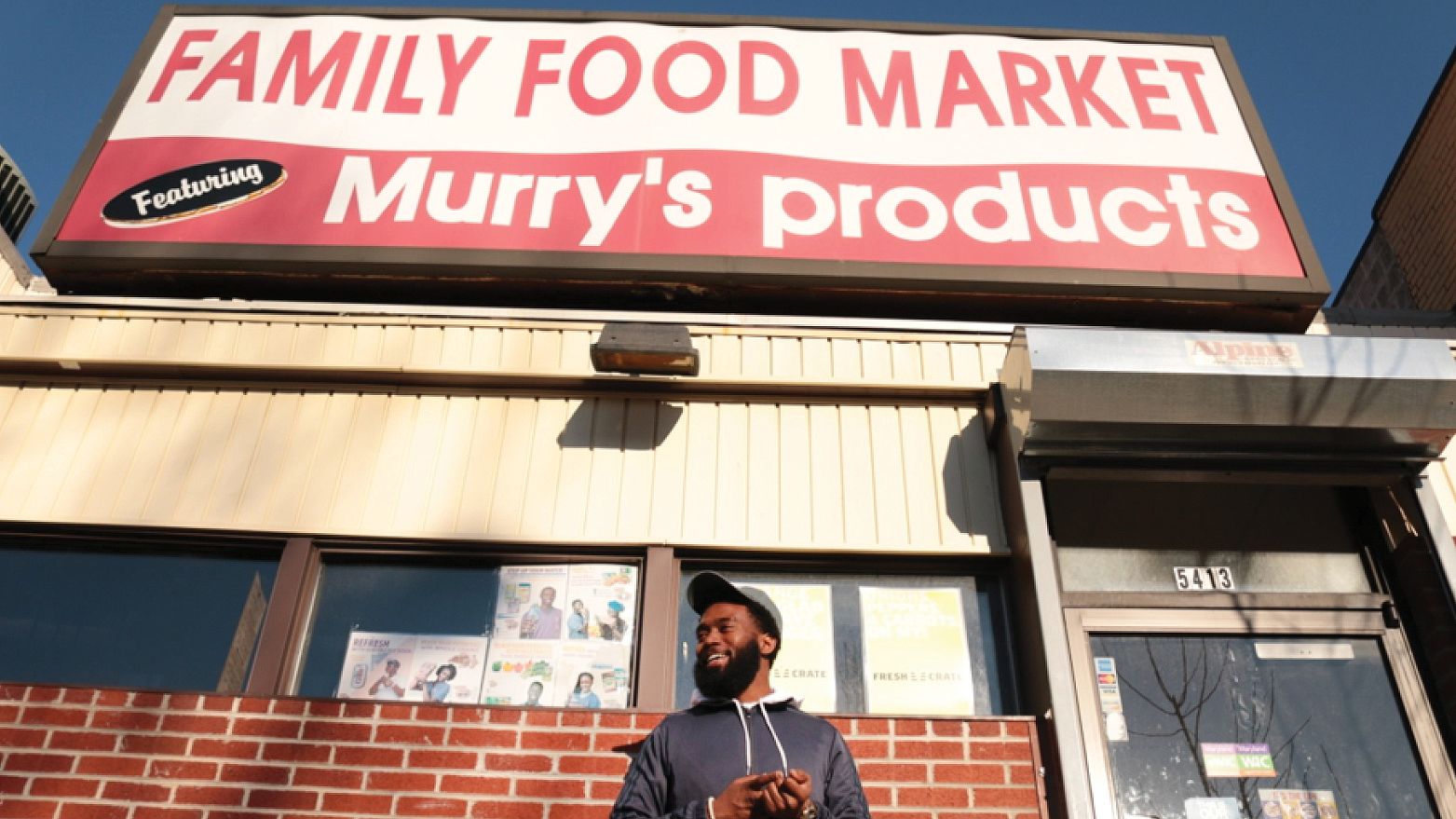 image of a black man standing in front of a market storefront