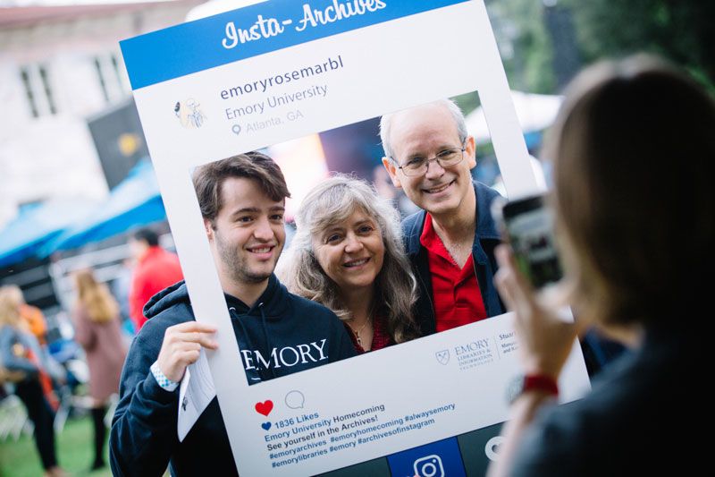 A student poses for a photo with his parents.