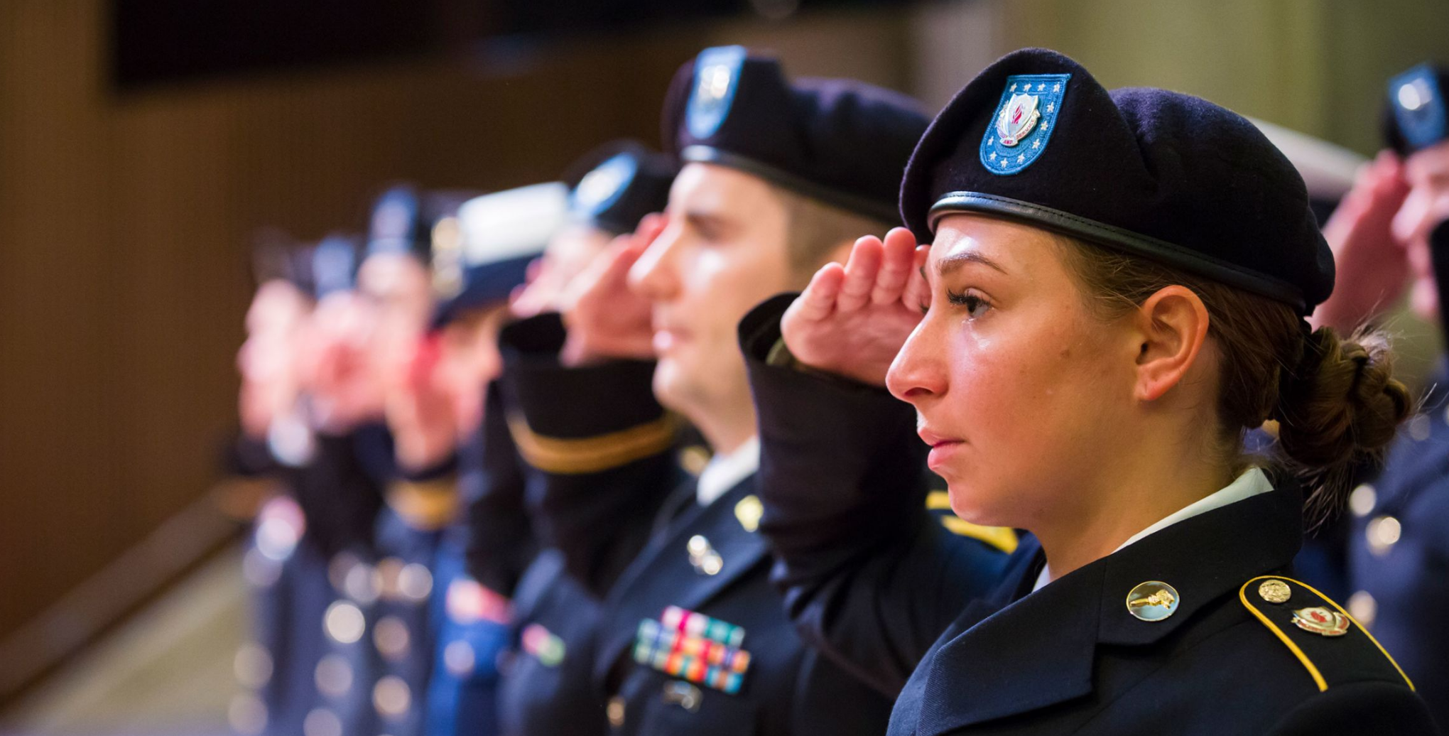 Men and women in uniform stand at attention by the Emory flag pole during the annual Veterans Day ceremony.