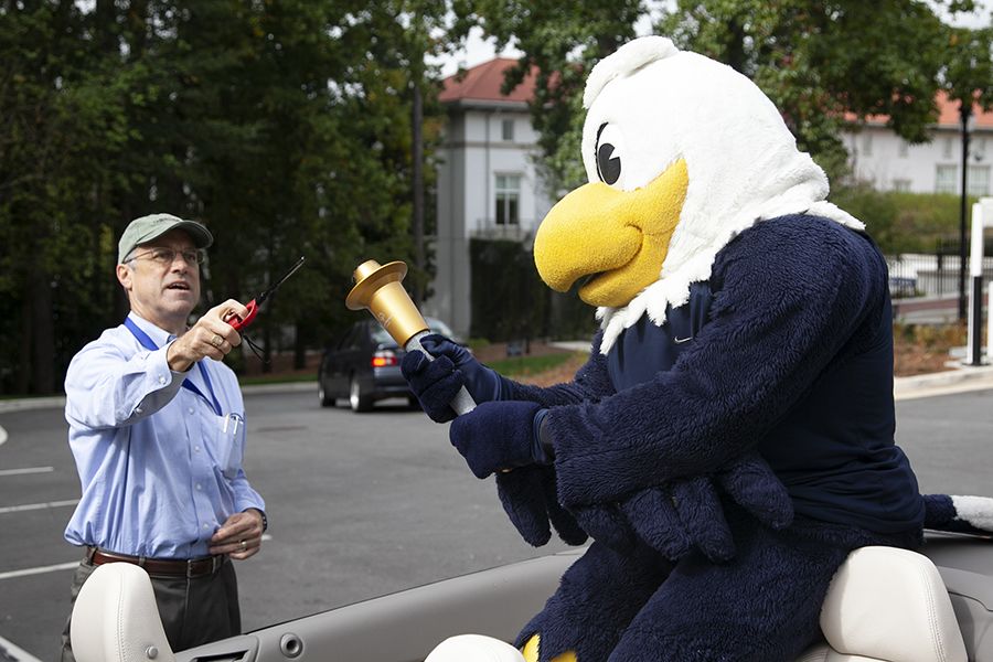 Hauk lighting Swoop's torch in anticipation of a relay race between the Oxford and Druid Hills campuses