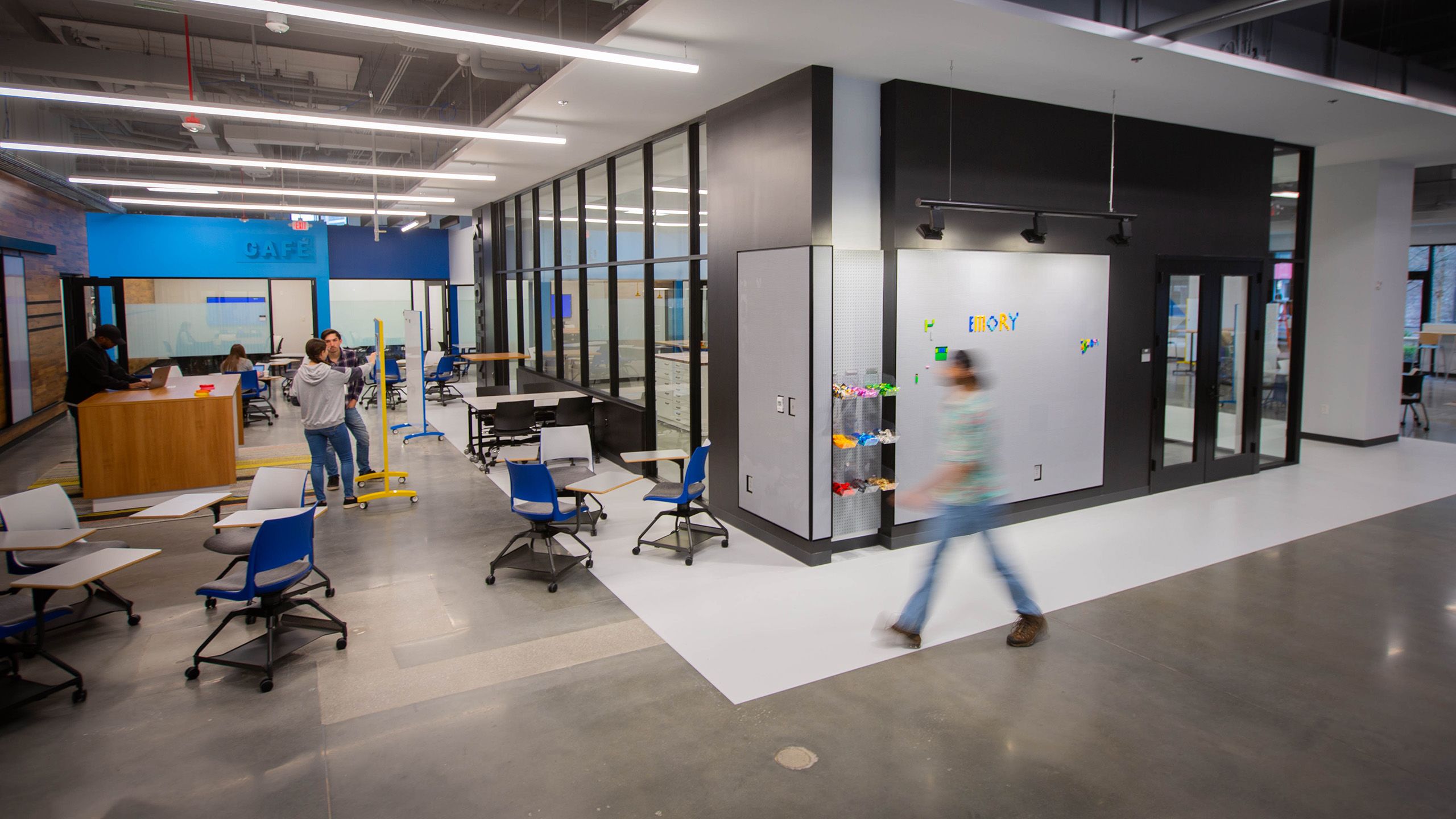 Two students are in discussion in front of a small whiteboard