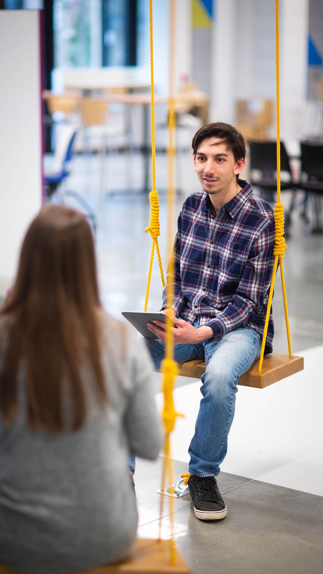 Three students on swings in discussion
