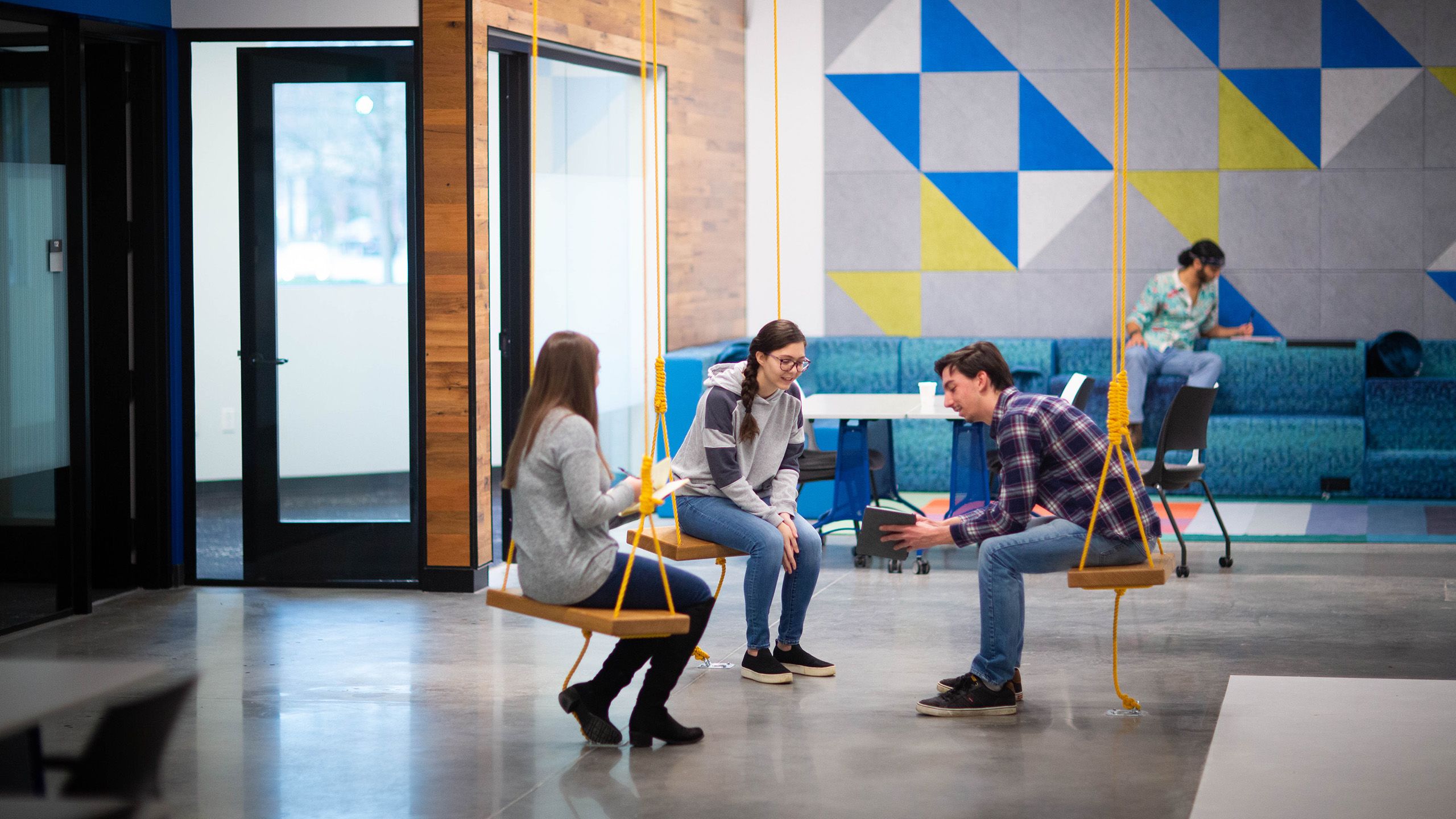 Three students on swings in discussion