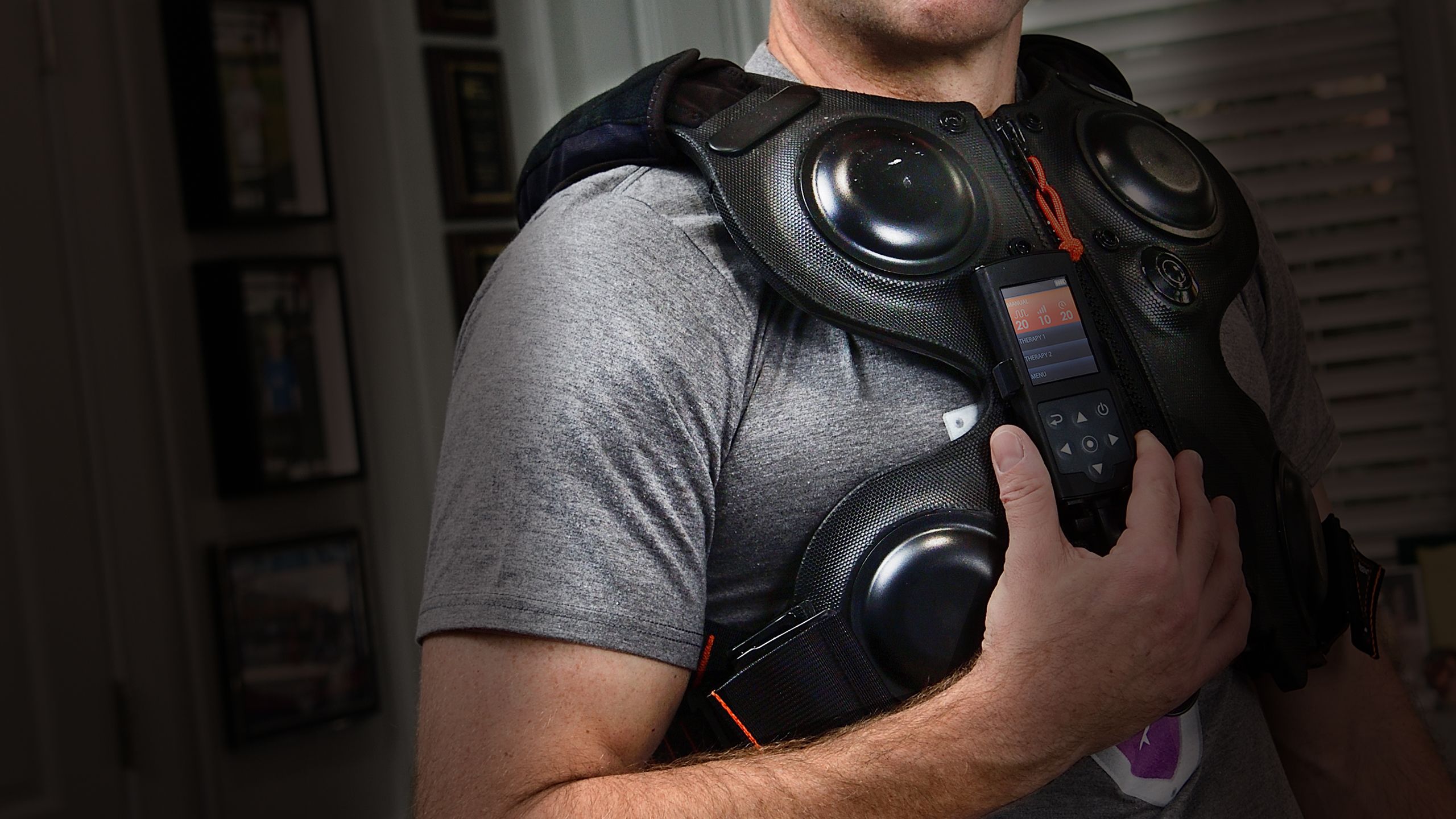 A man's torso wearing a percussive vest for cystic fibrosis therapy to break up mucus in lungs. 