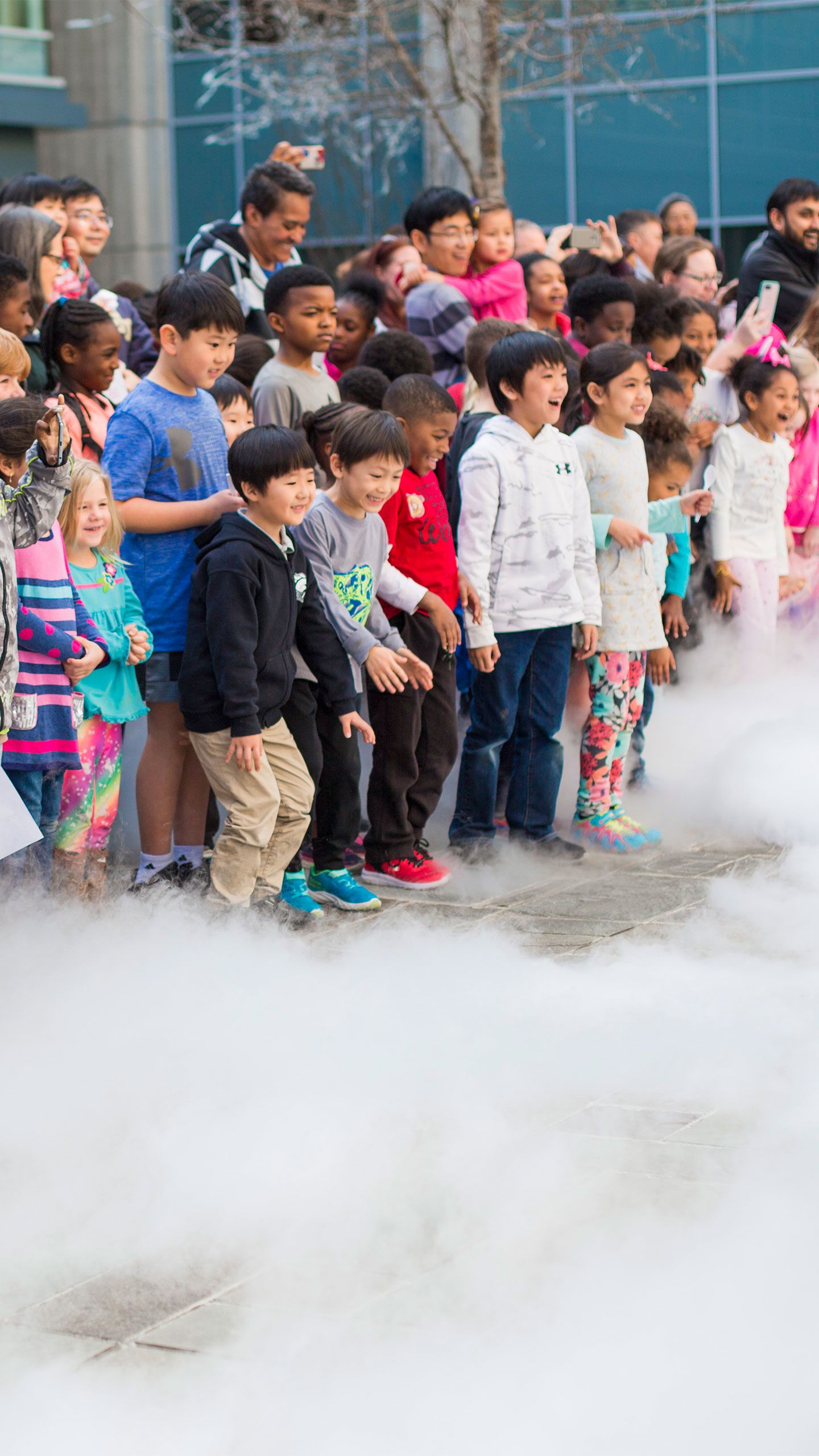 Kids point and smile as the white cloud-like steam moves toward them.