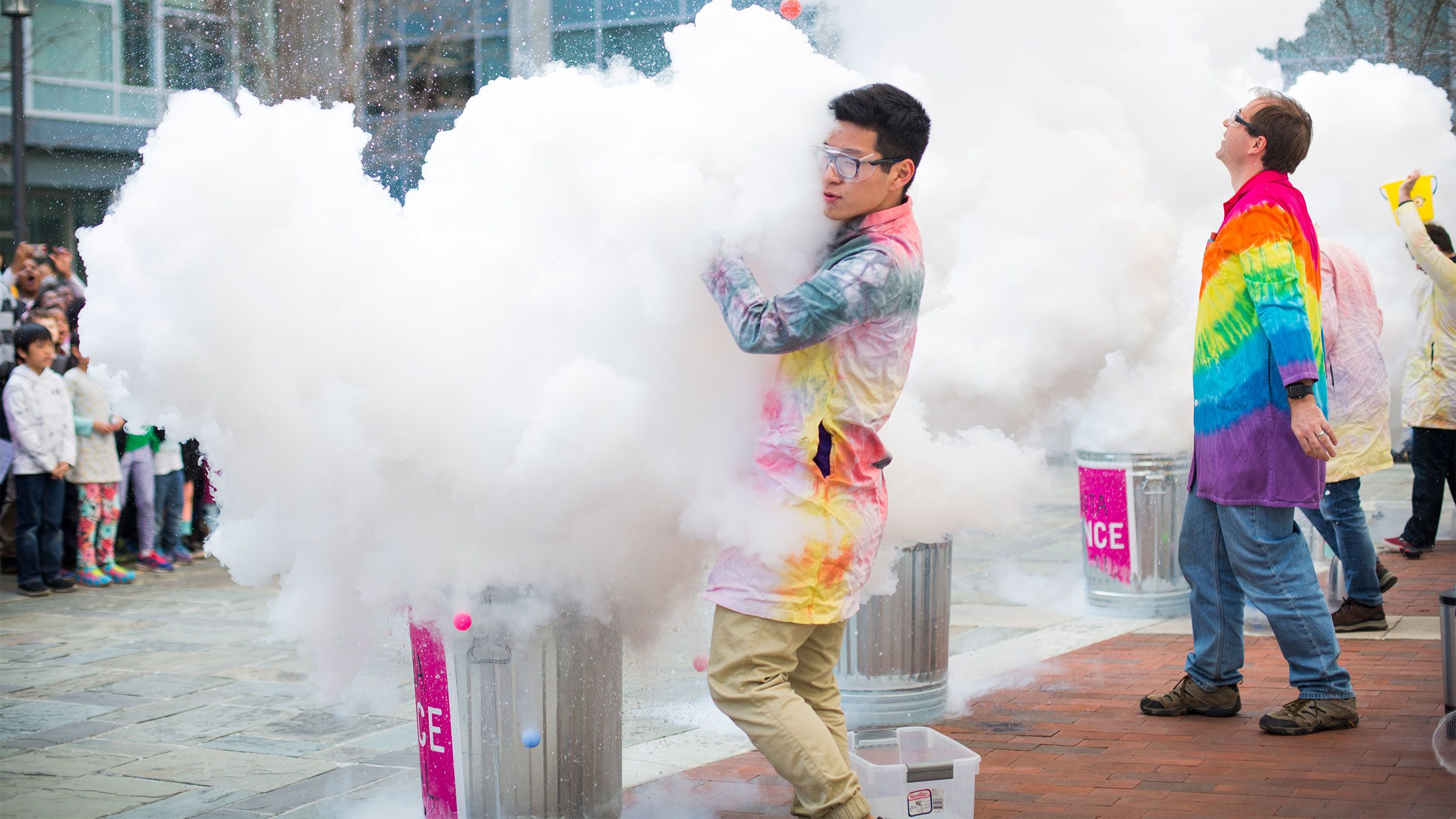 Giant clouds of white rise up from trash cans as they pour the liquid in.