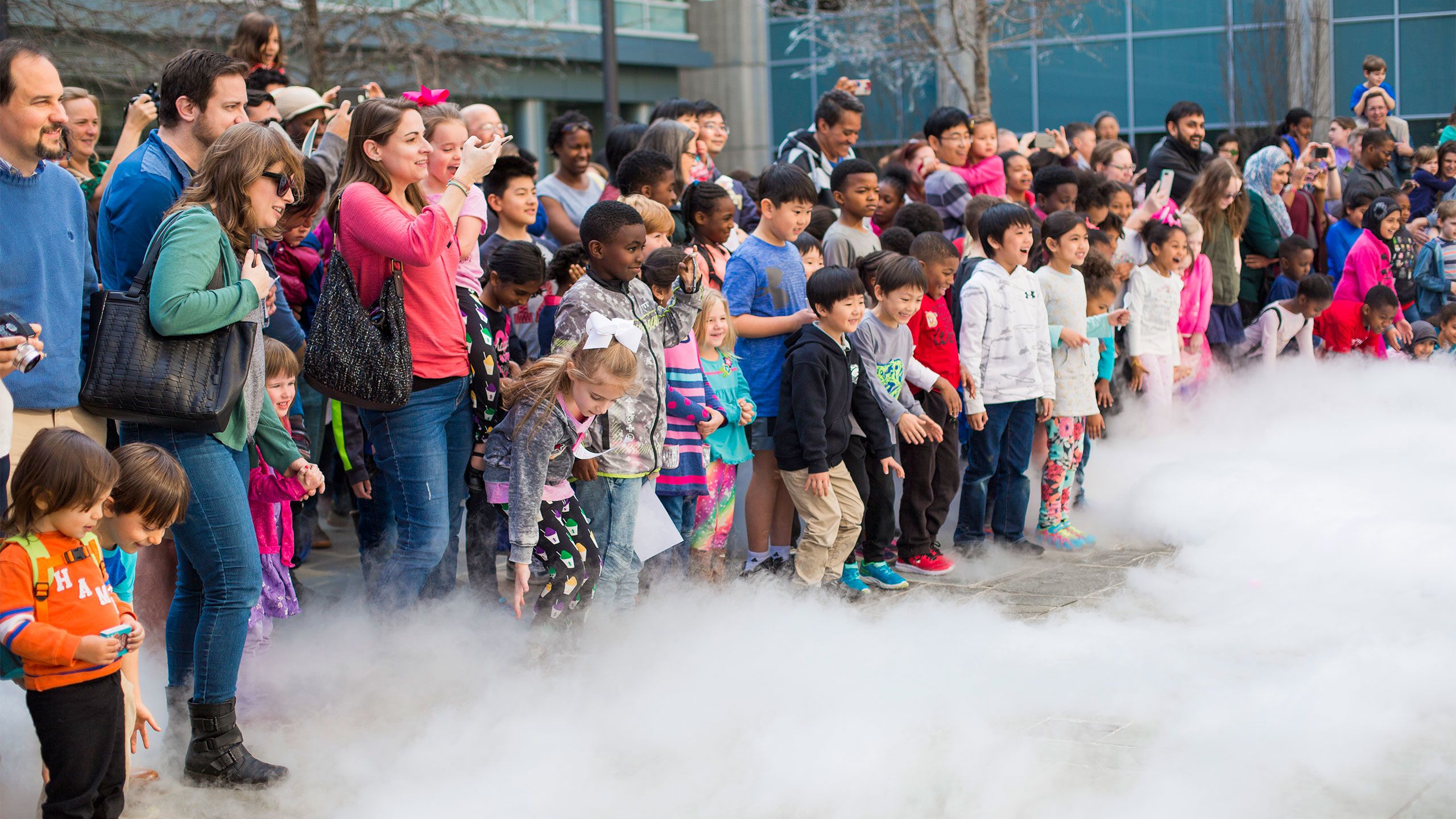 Kids point and smile as the white cloud-like steam moves toward them.