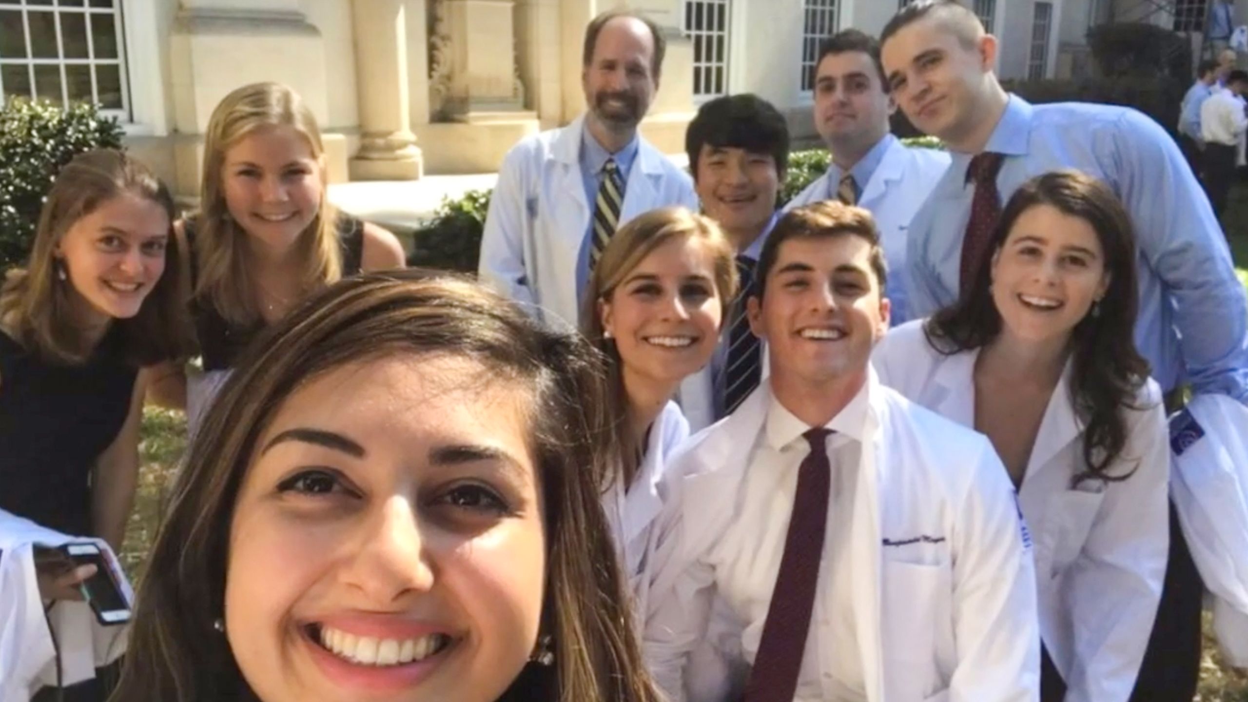 A selfie of a group of medical students in white coats at the white coat ceremony.