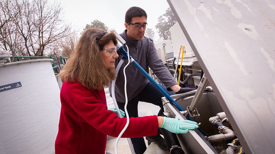 Christine Moe with assistant testing water