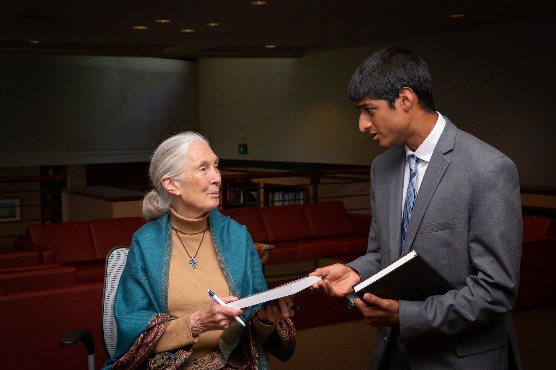 A student receives a book from a woman