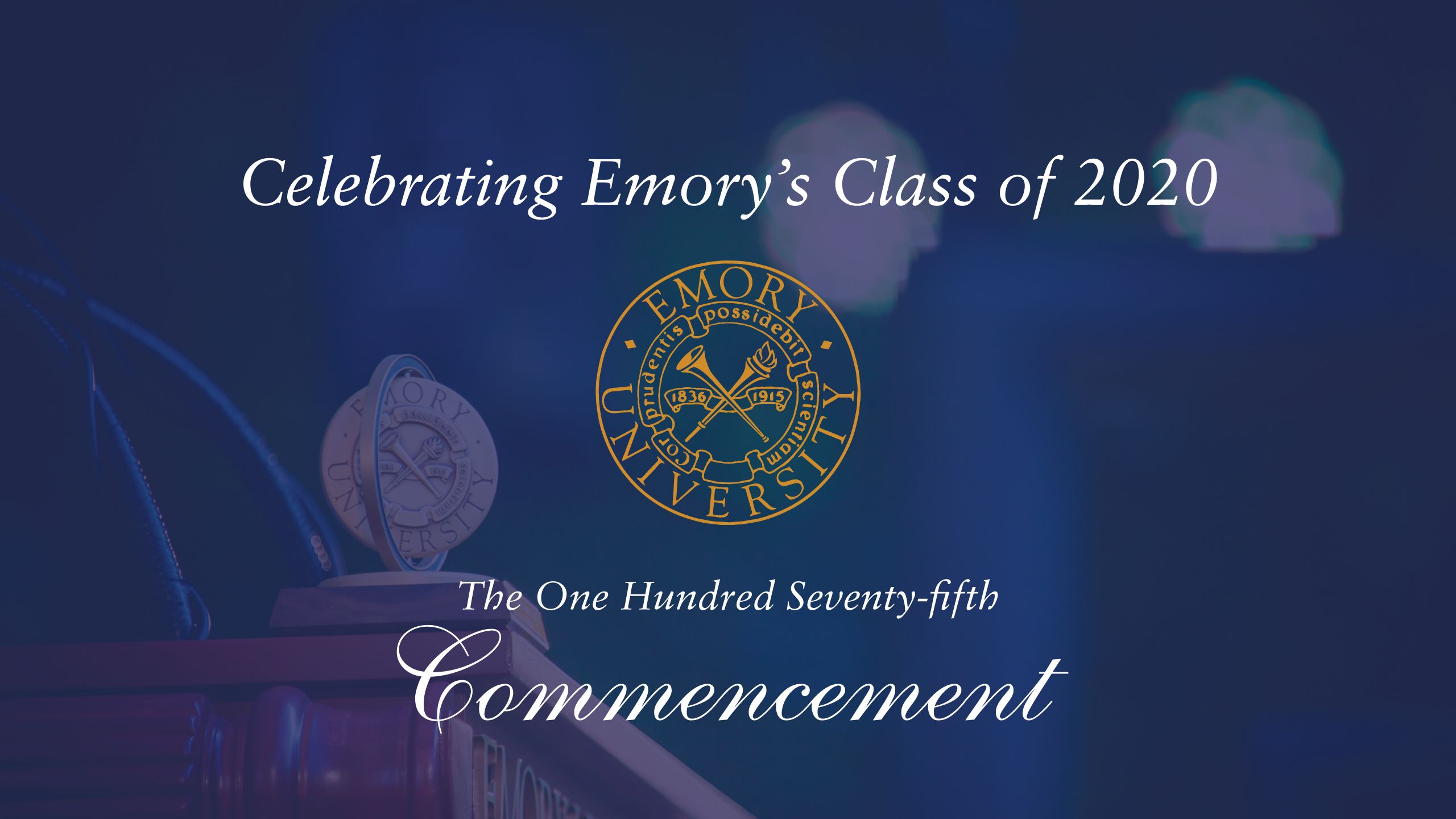 Students in caps and gowns sit in rows at Commencement