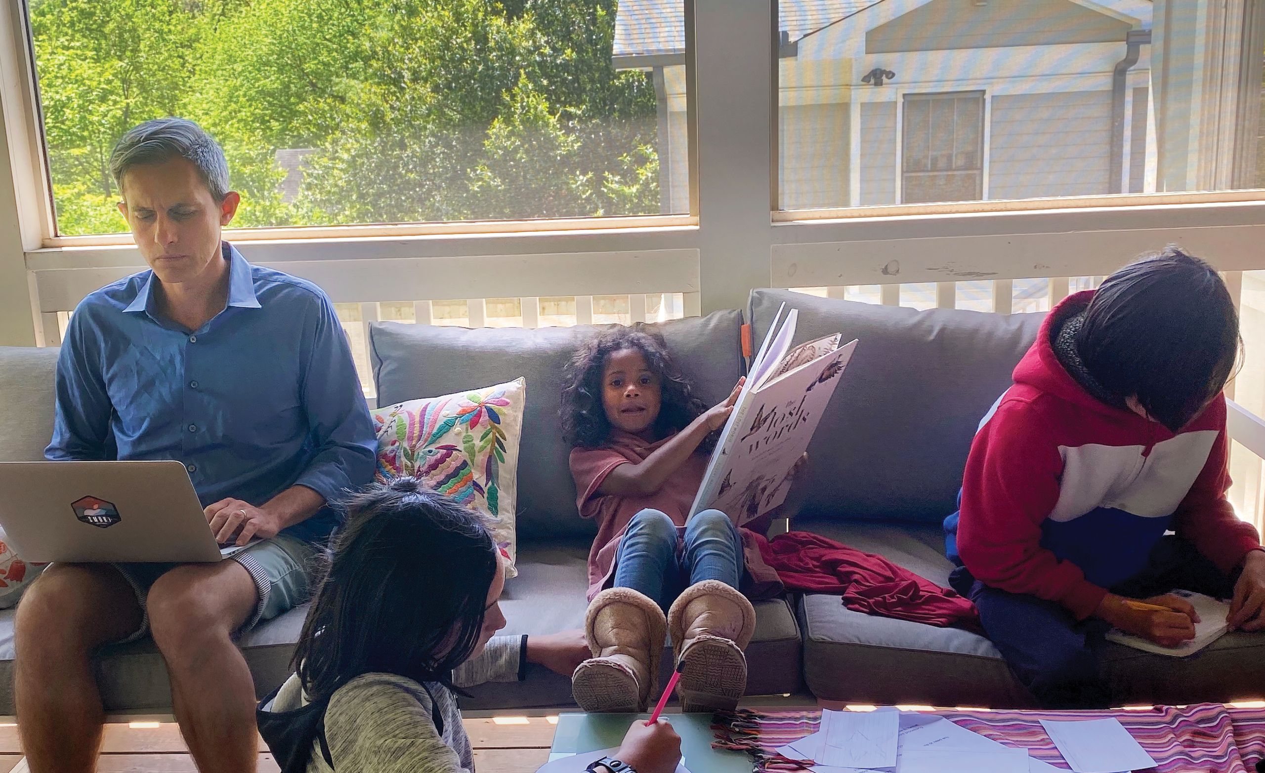 Ben Lopman with his children on the porch doing virtual learning.